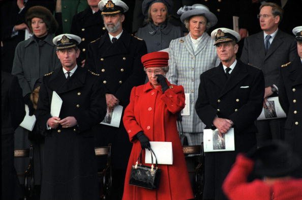 11 DE DICIEMBRE 1997: La Reina se limpió una lágrima de los ojos en la ceremonia de retirada del servicio del Hmy Britannia. Junto a ella, los príncipes Phillip y Charles y, detrás, su dama de compañía, la duquesa de Grafton. | Foto: Getty Images
