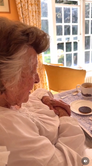 Lady Pamela Hicks is seen nestled comfortably in bed, dressed in a flowing white nightgown as soft morning light filters through the windows behind her. The intimate moment captures her in quiet reflection as she begins her 97th birthday with a simple breakfast tray by her side, offering a rare and personal glimpse into her private world. | Source: Instagram/indiahicksstyle