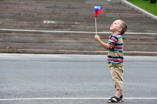 A young boy pictured holding a flag | Photo: Getty Images