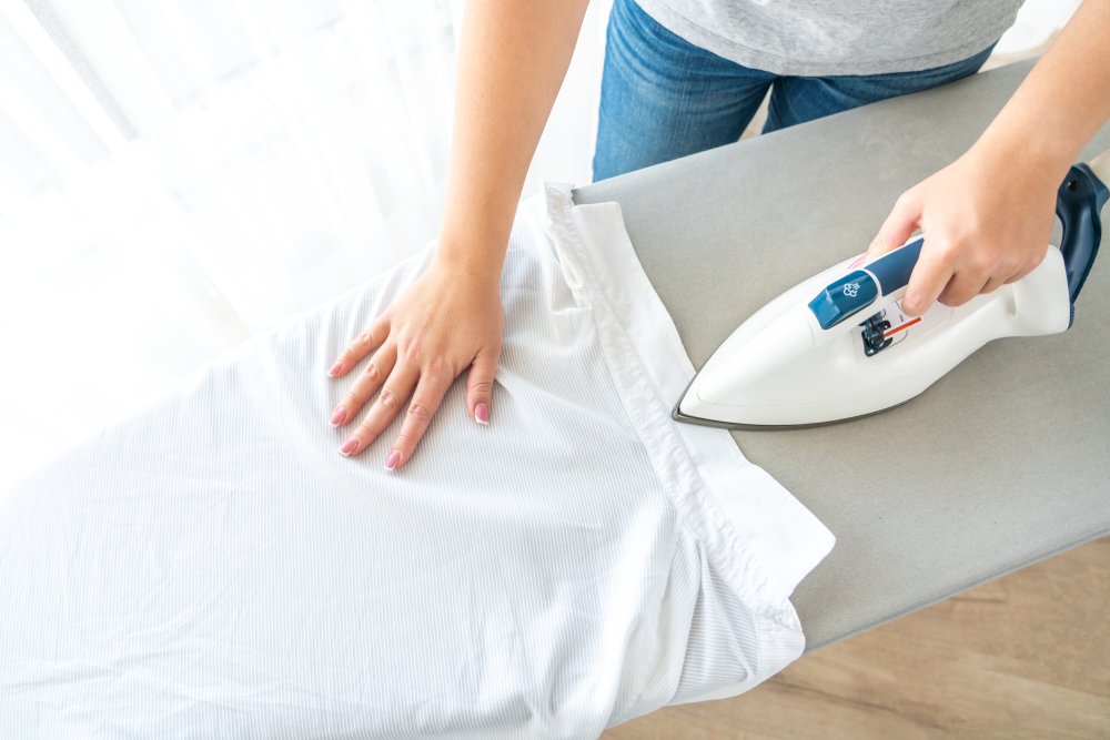 A photo of someone ironing a shirt. | Photo: Shutterstock