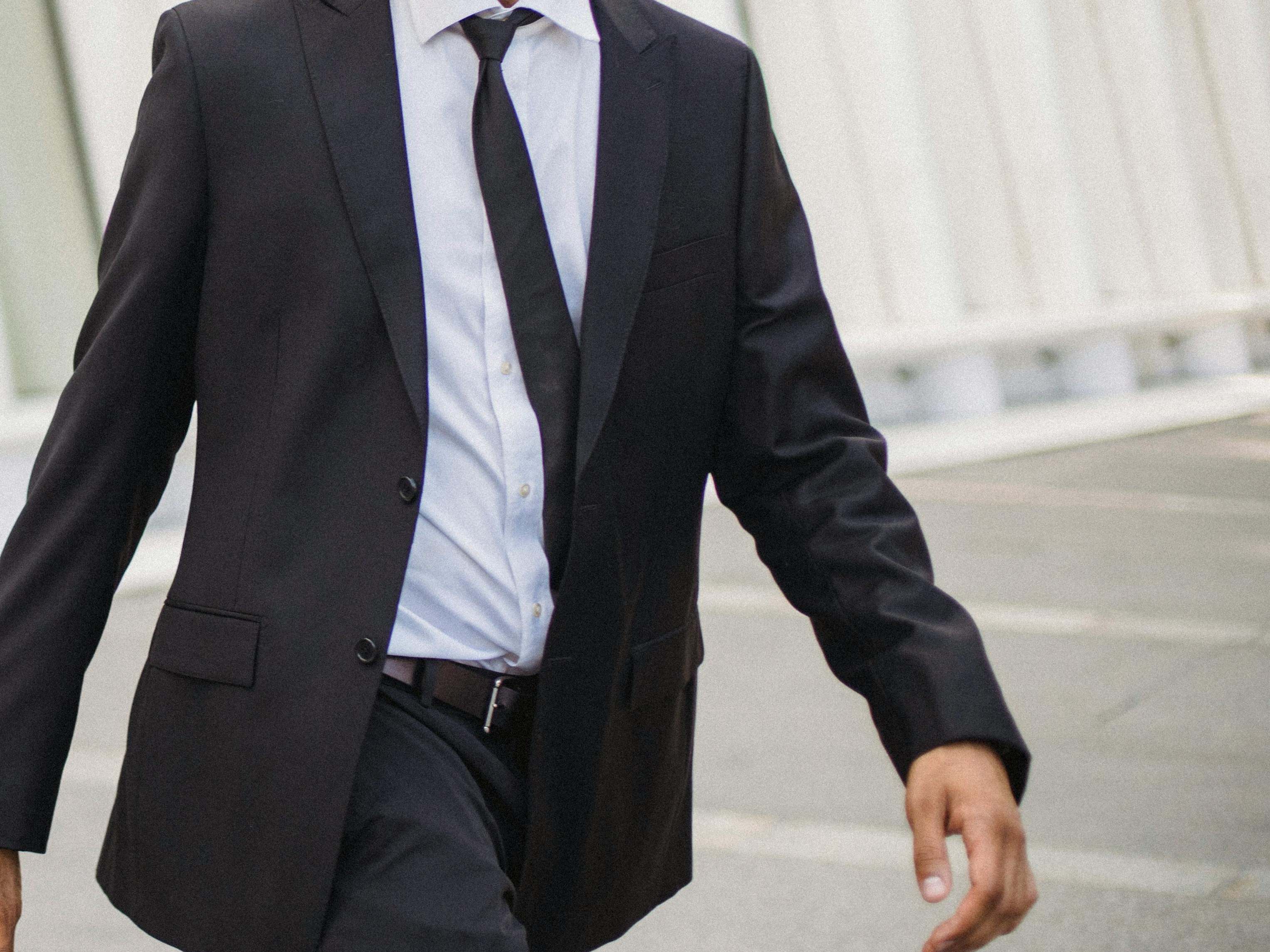 A man in a suit and tie, walking hastily | Source: Pexels