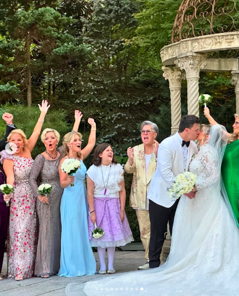 Blake and Teresa O'Donnell sharing a kiss on their wedding day alongside Rosie O'Donnell, Anne Steele, Kelli Carpenter and other loved ones, posted on August 18, 2024 | Source: Instagram/theannesteele