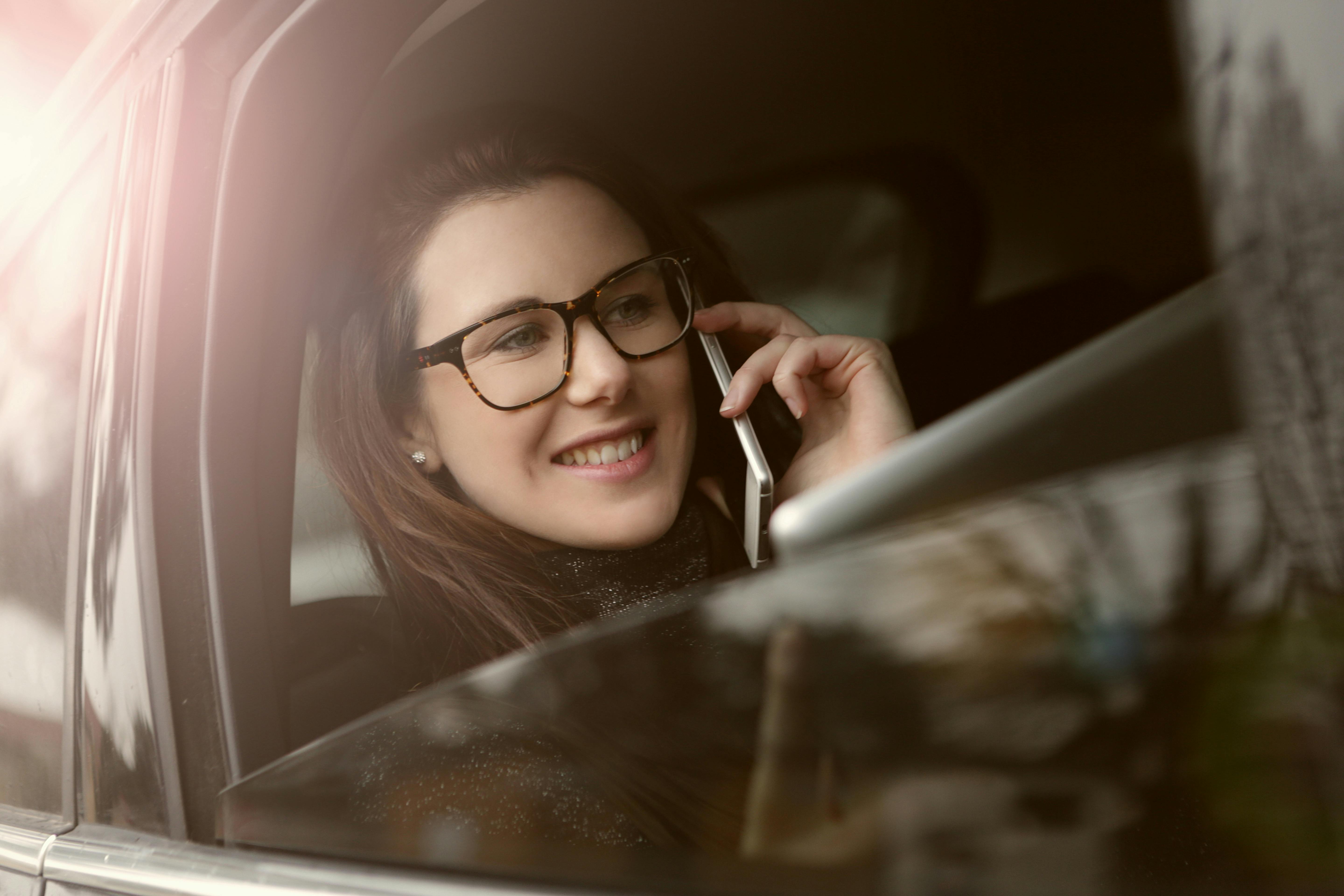 A woman smiling while on phone | Source: Pexels