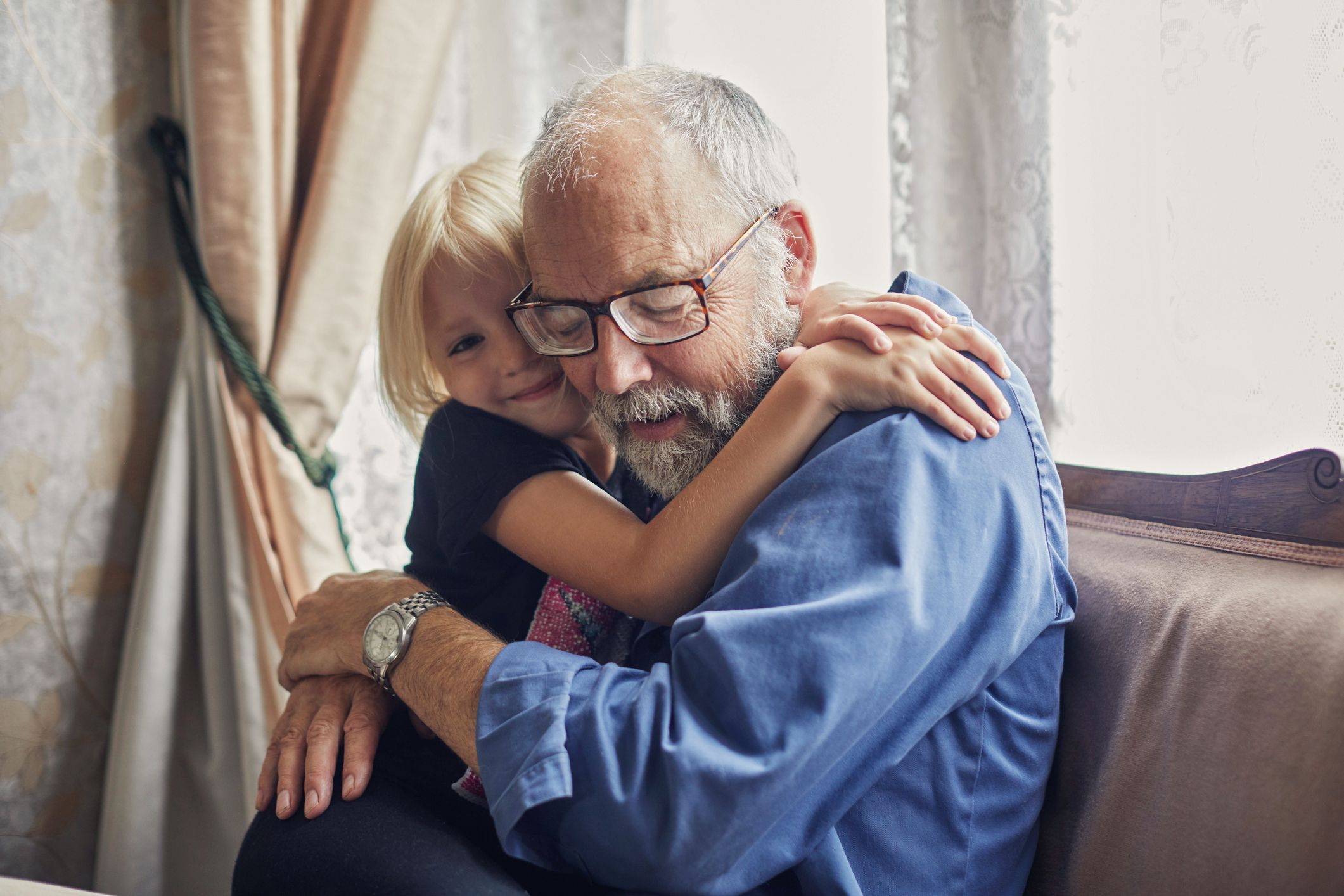 A grandfather hugging his grandchild. | Source: Shutterstock