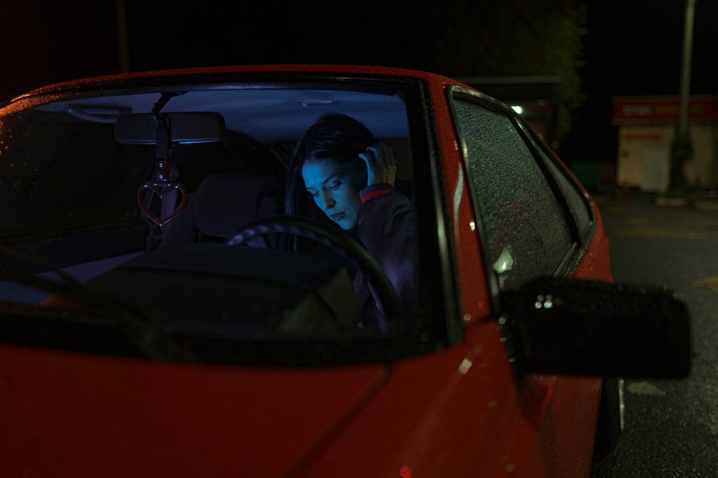 Una mujer dentro de un automóvil mirando su teléfono celular. | Foto: Pexels