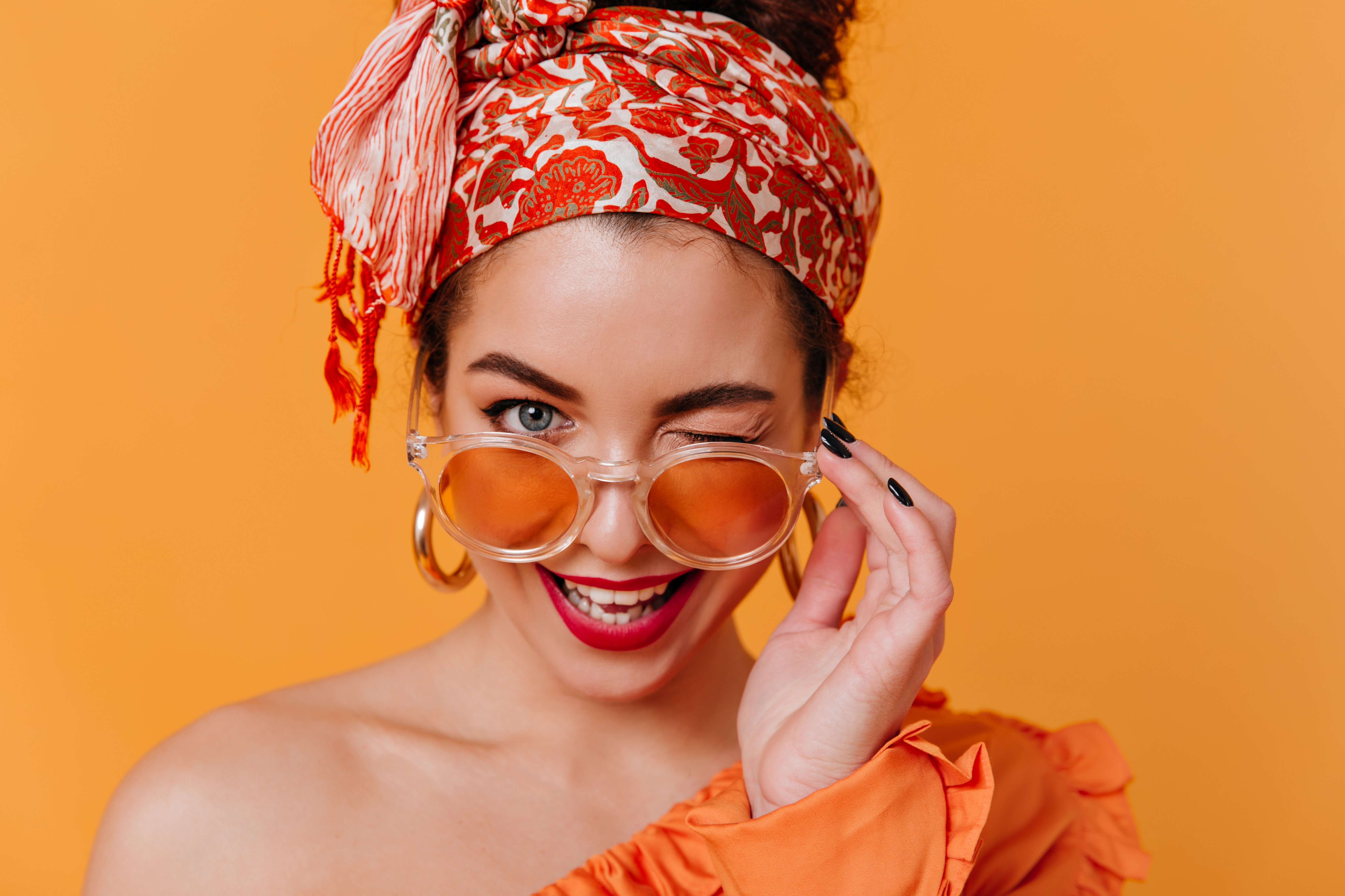Woman wearing orange hair scarf | Shutterstock