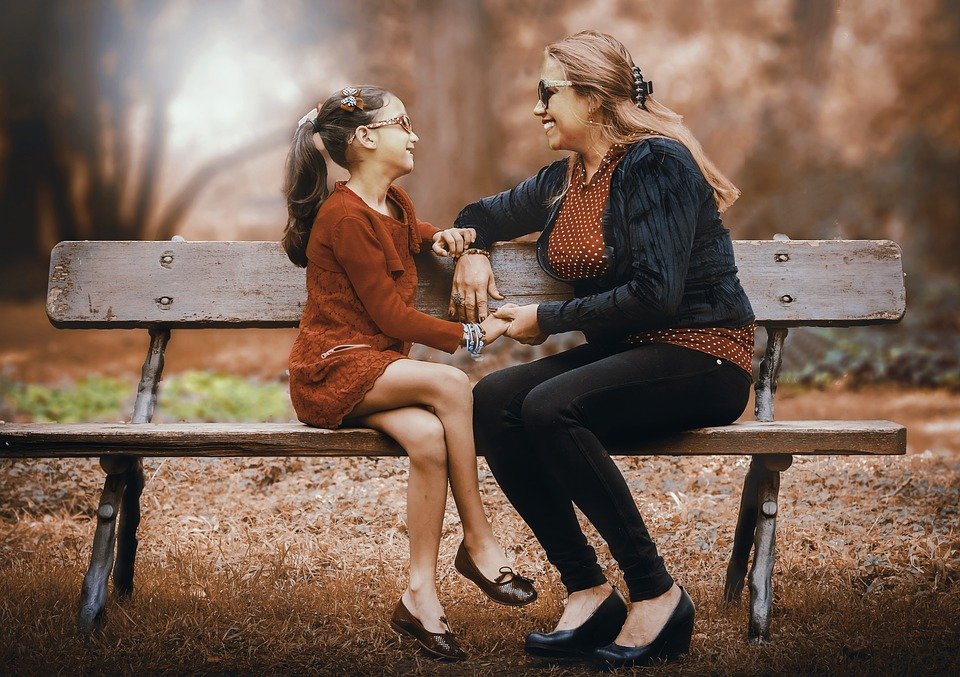 Une mère et sa fille assises dans le parc. | Image : Pixabay