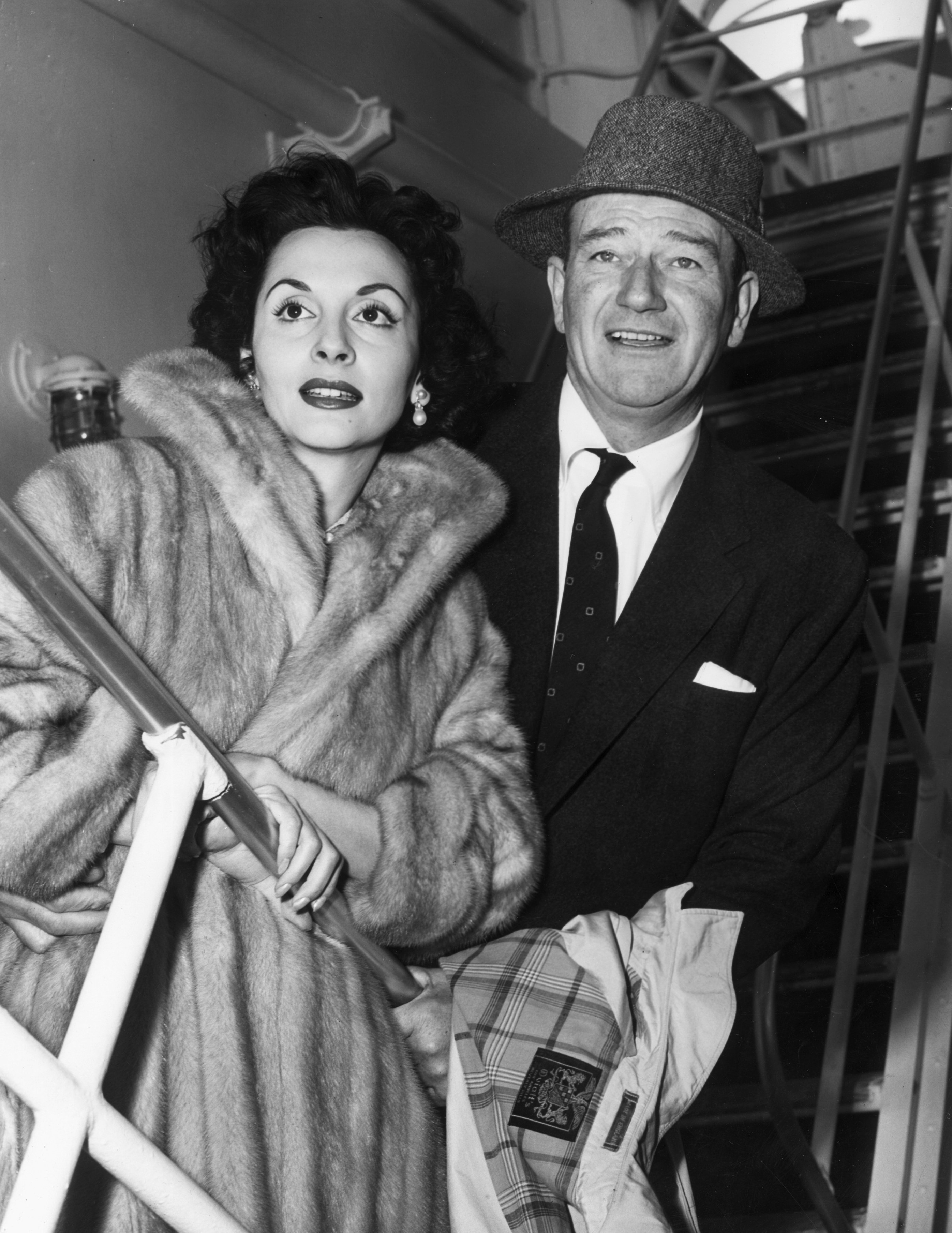 American actor John Wayne sets sail with his wife, Pilar Palette, for Tripoli, Lebanon, to star in director Henry Hathaway's film, 'Legend of the Lost', in 1956. | Source: Getty Images