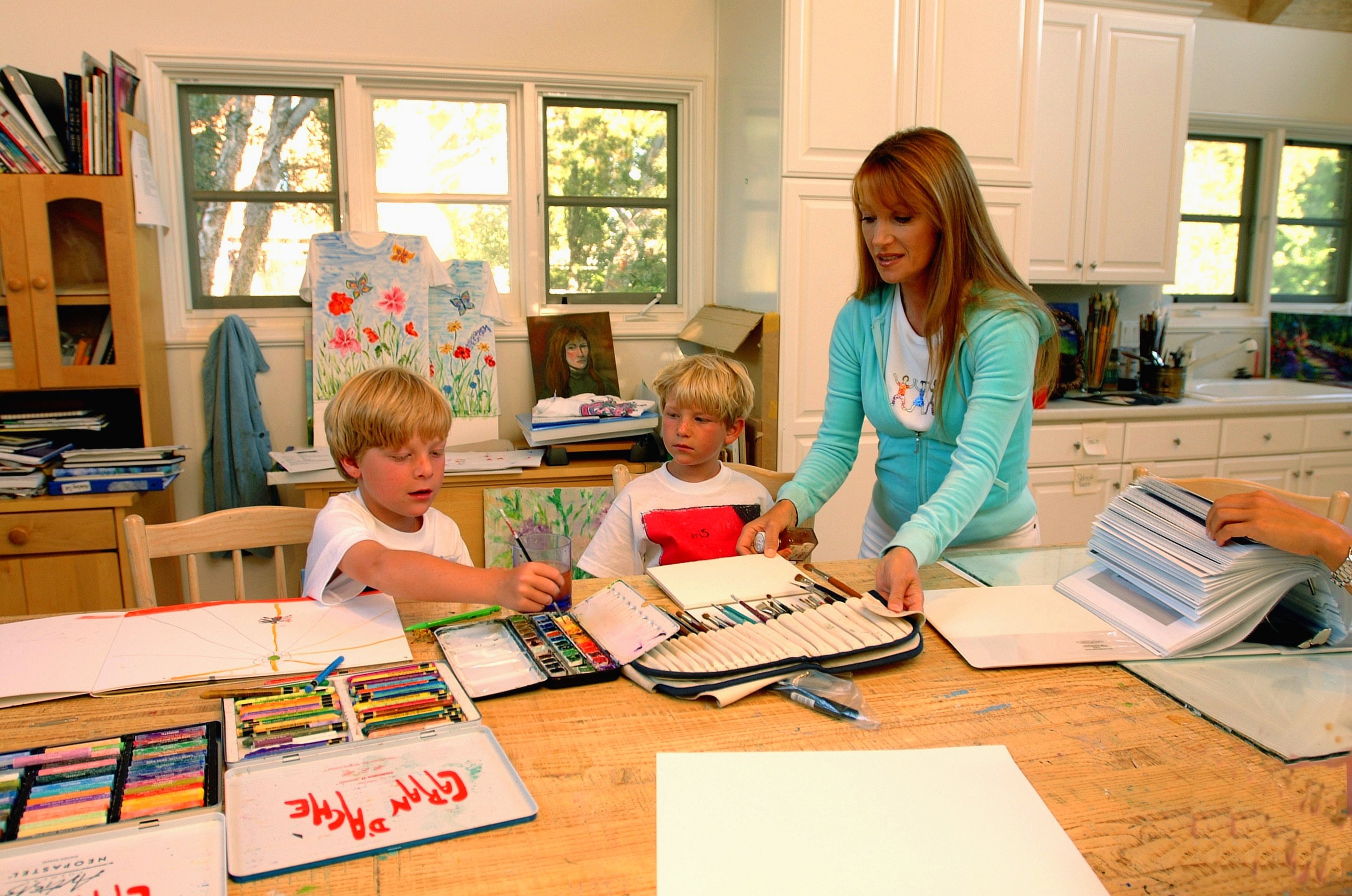 Jane Seymour stands in her art studio and dressing room with her twin sons John and Christopher at her home overlooking the Pacific ocean with various items of her fashion designs and artwork on June 12, 2002. in Malibu, California. | Source: Getty Images