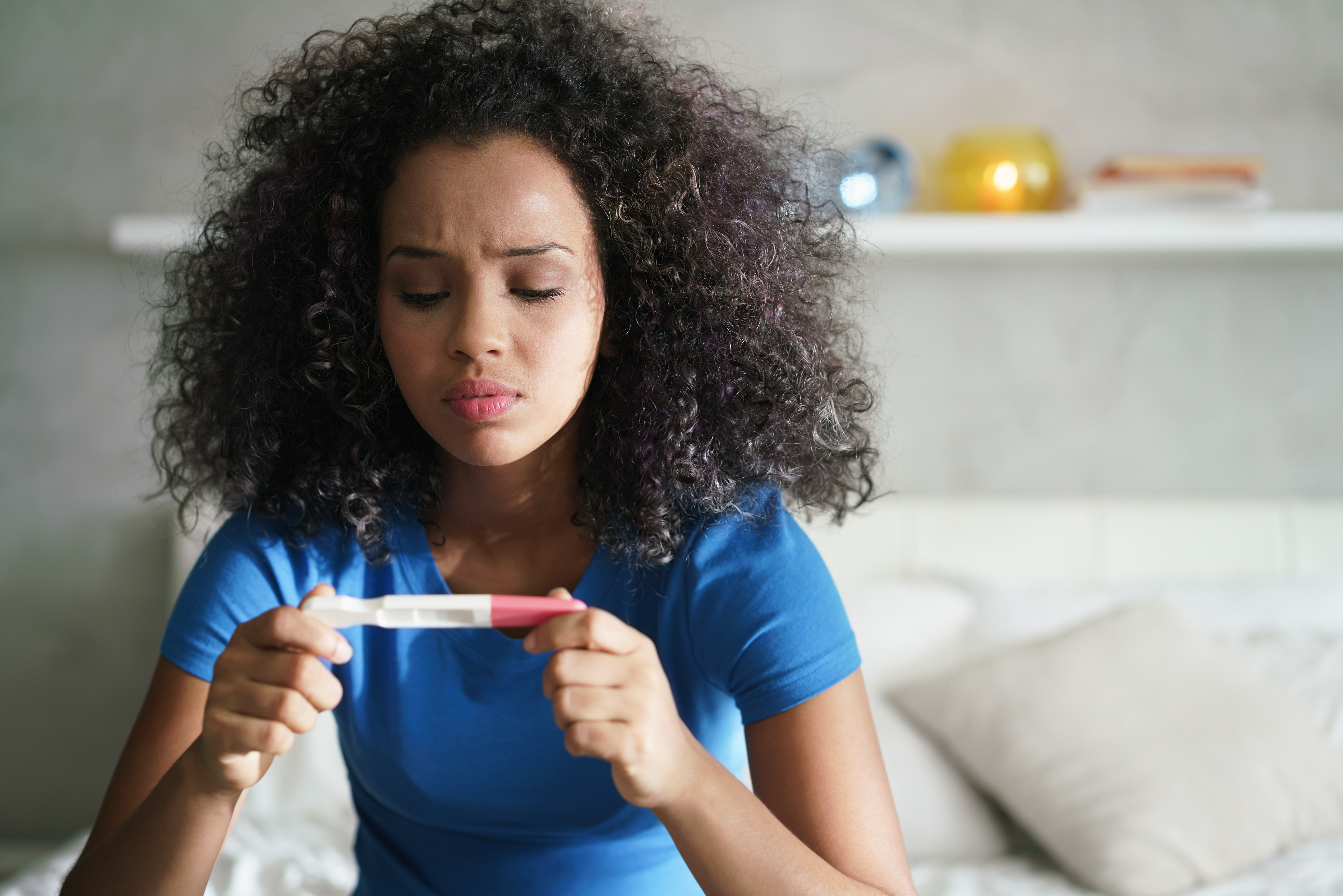 Girl with pregnancy test in her room | Source: Shutterstock.com