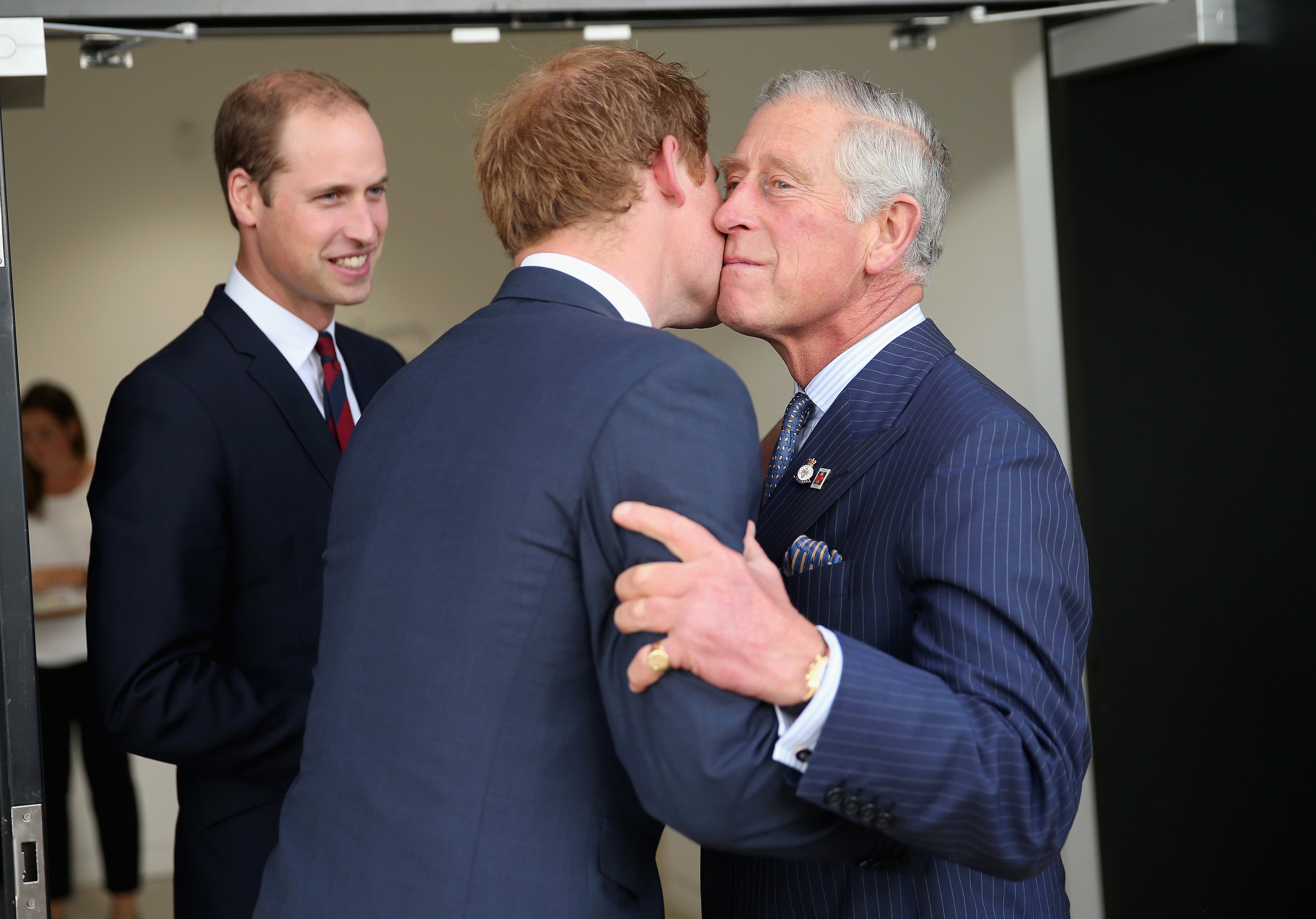 Prince Charles, Prince of Wales kisses his son Prince Harry as Prince William, Duke of Cambridge looks on at the Invictus Games Opening Ceremony at Queen Elizabeth II Park on September 10, 2014 in London, England. | Source: Getty Images