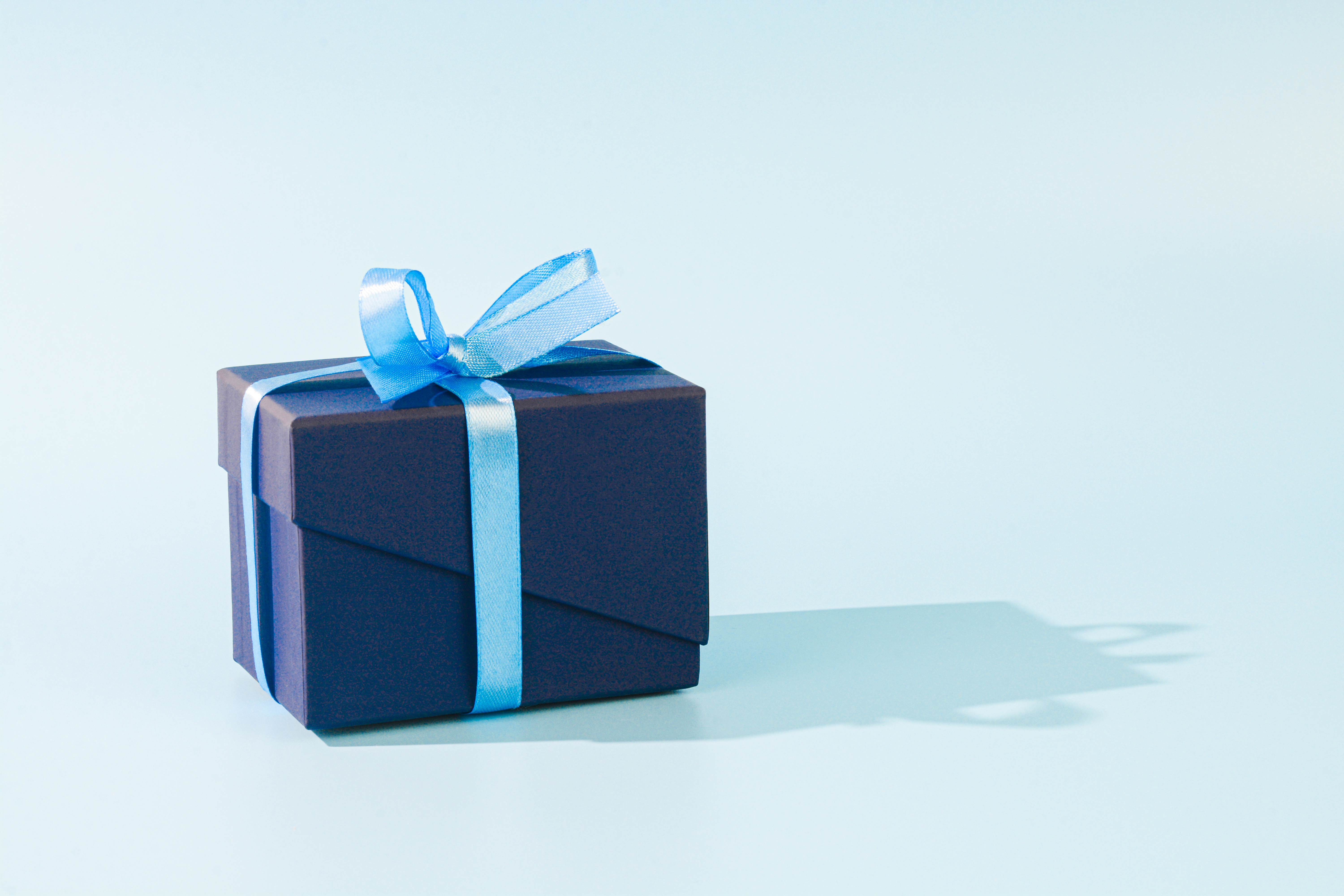 A gift wrapped with dark blue paper and a light blue ribbon | Source: Getty Images