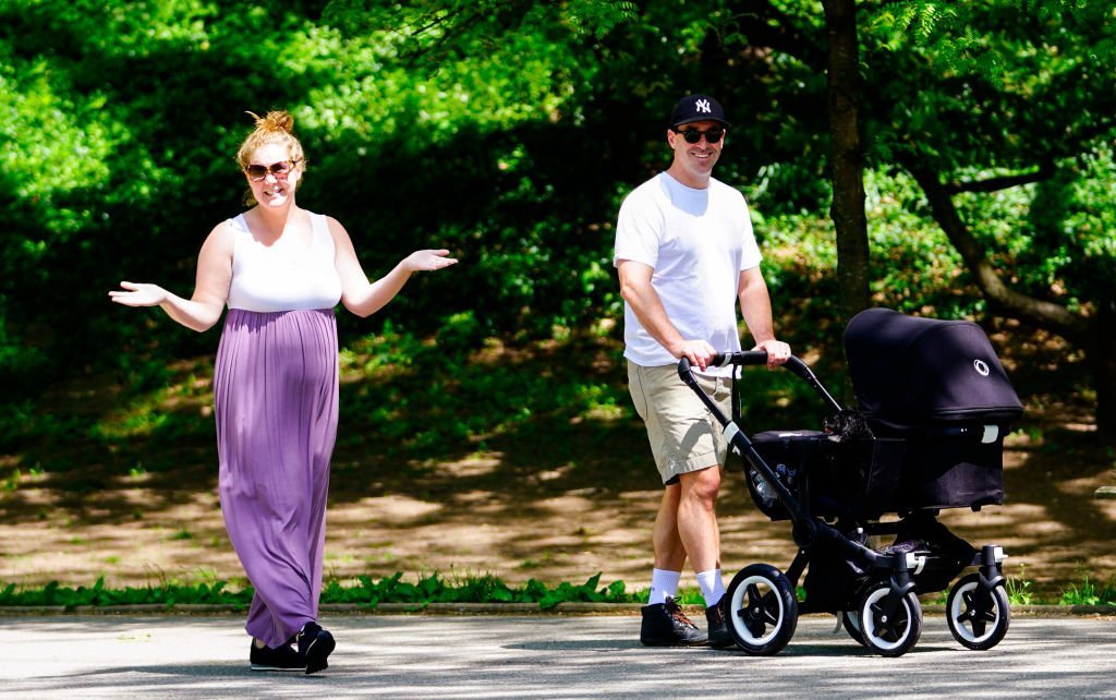 Amy Schumer and Chris Fischer take baby Gene Attell Fischer and their dog to the park on May 18, 2019. | Photo: Getty Images