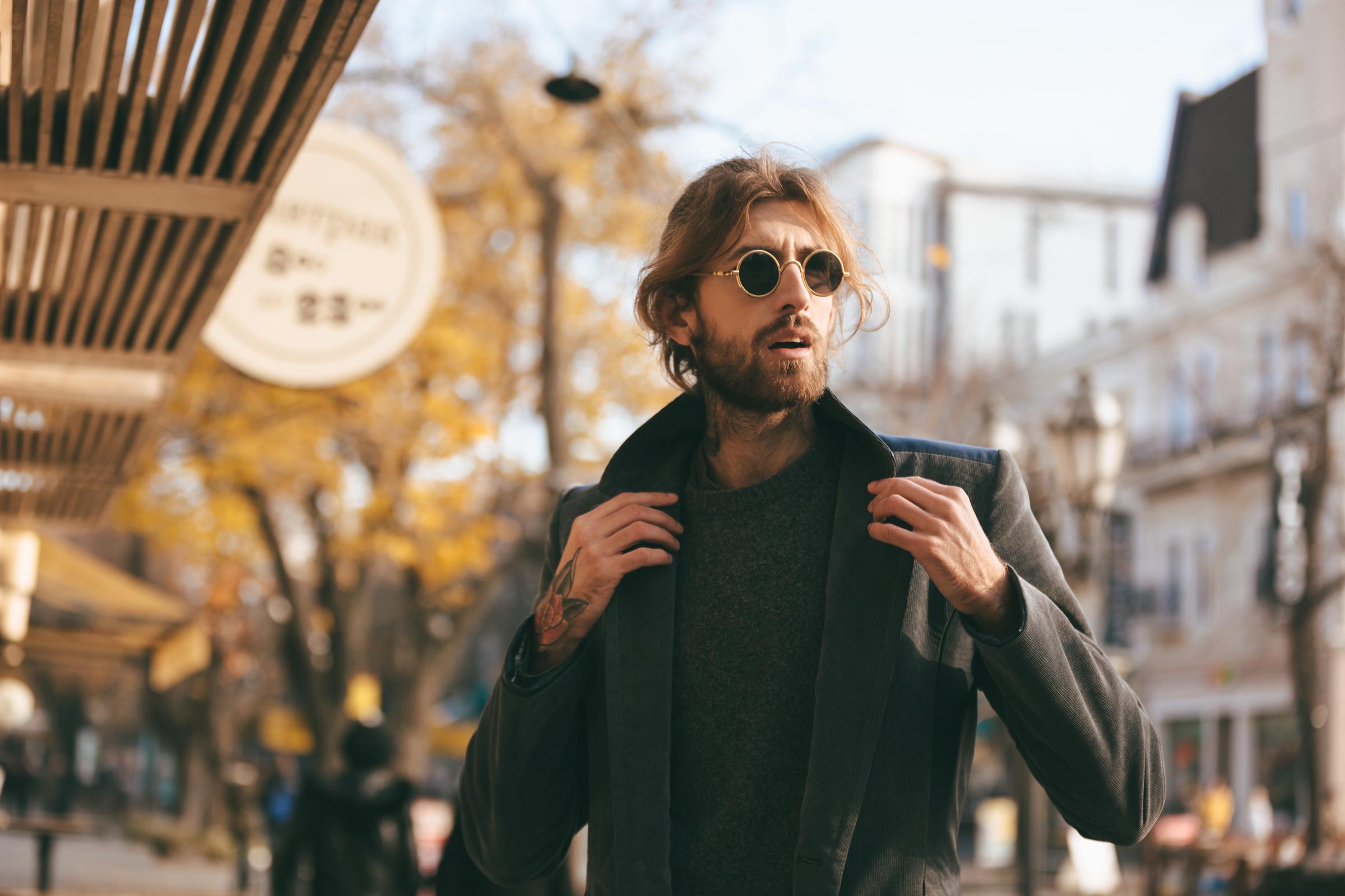 A handsome man wearing sunglasses and a coat | Source: Freepik