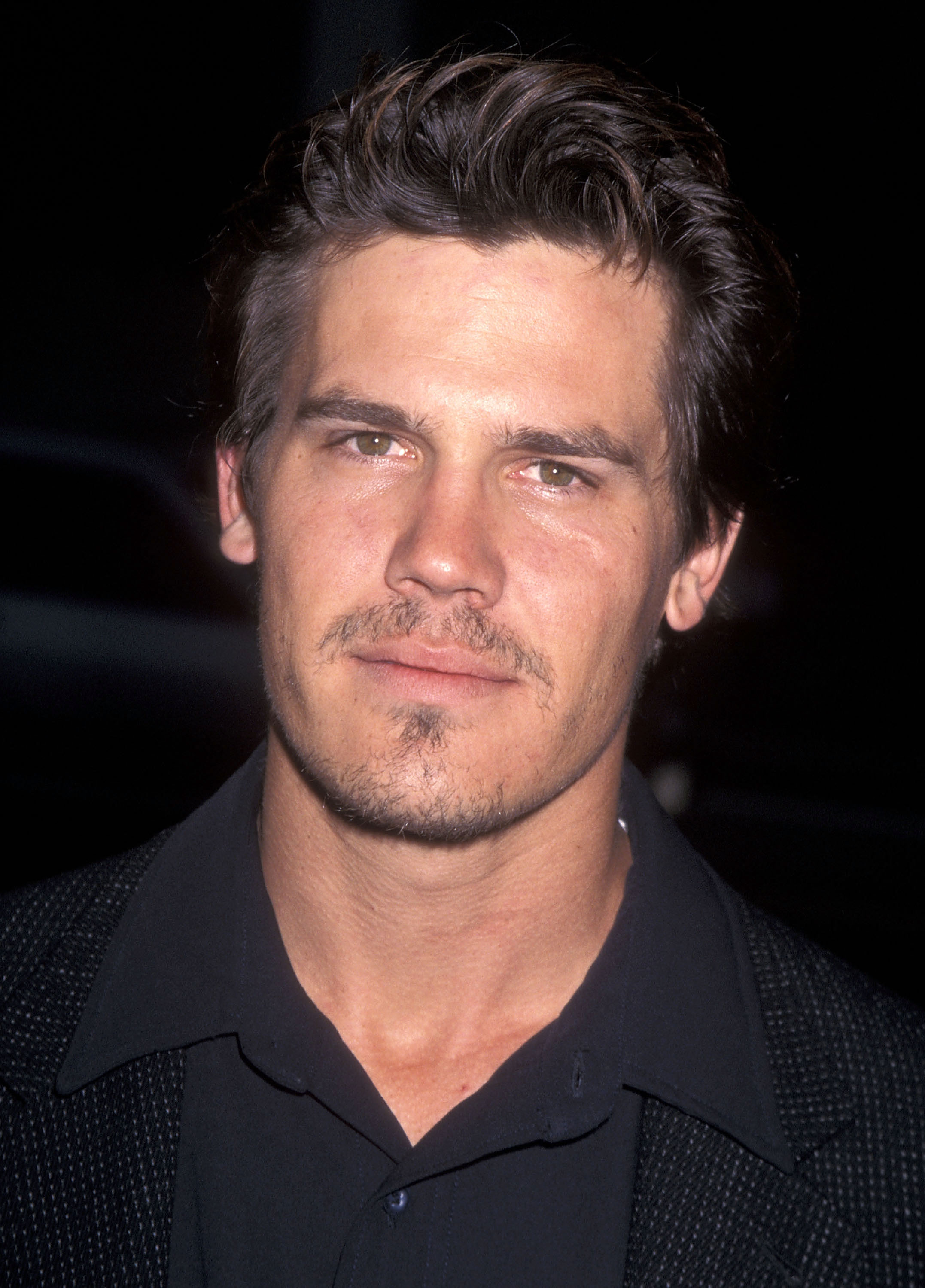 Brolin steps onto the red carpet for the “I Shot Andy Warhol” premiere, his expression cool and unreadable. With tousled hair, a dark shirt, and a hint of a goatee.