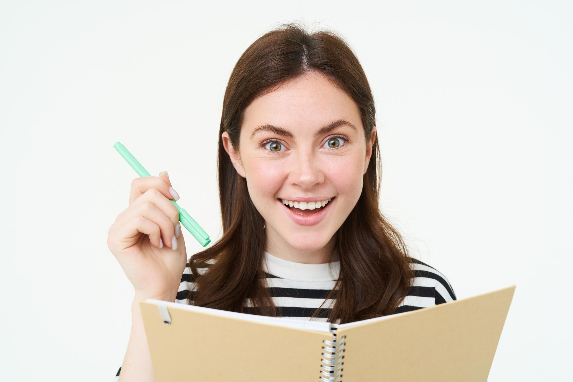 A woman holding a pen and a notebook | Source: Freepik