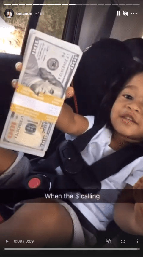 A screenshot from a video of Omarion's daughter, A'mei Kazuko Grandberry with wads of cash on Instagram | Photo: Instagram/omarion