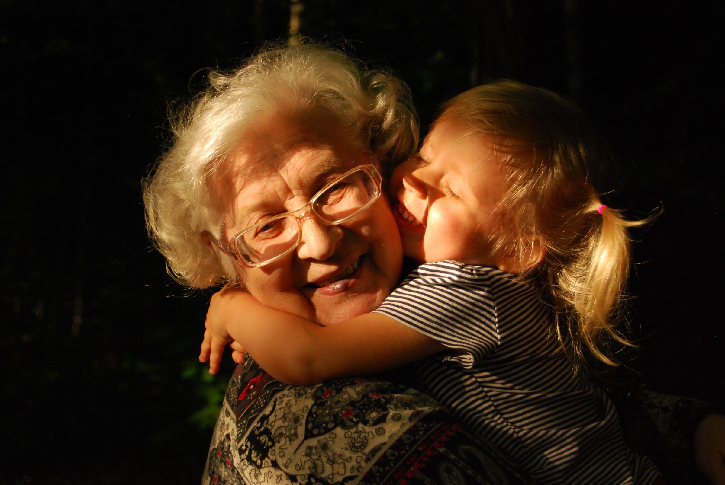 Eine Frau, die ihre Enkelin umarmt. | Quelle: Unsplash