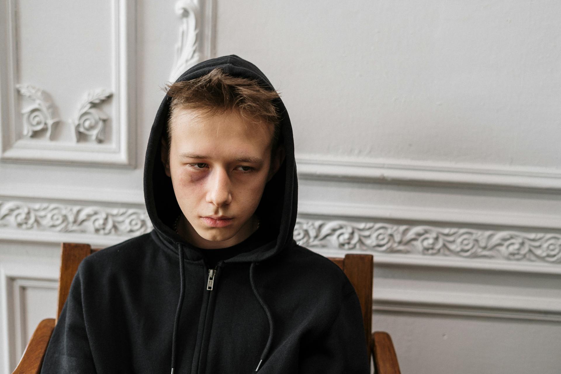 Teen boy sitting in a chair | Source: Pexels