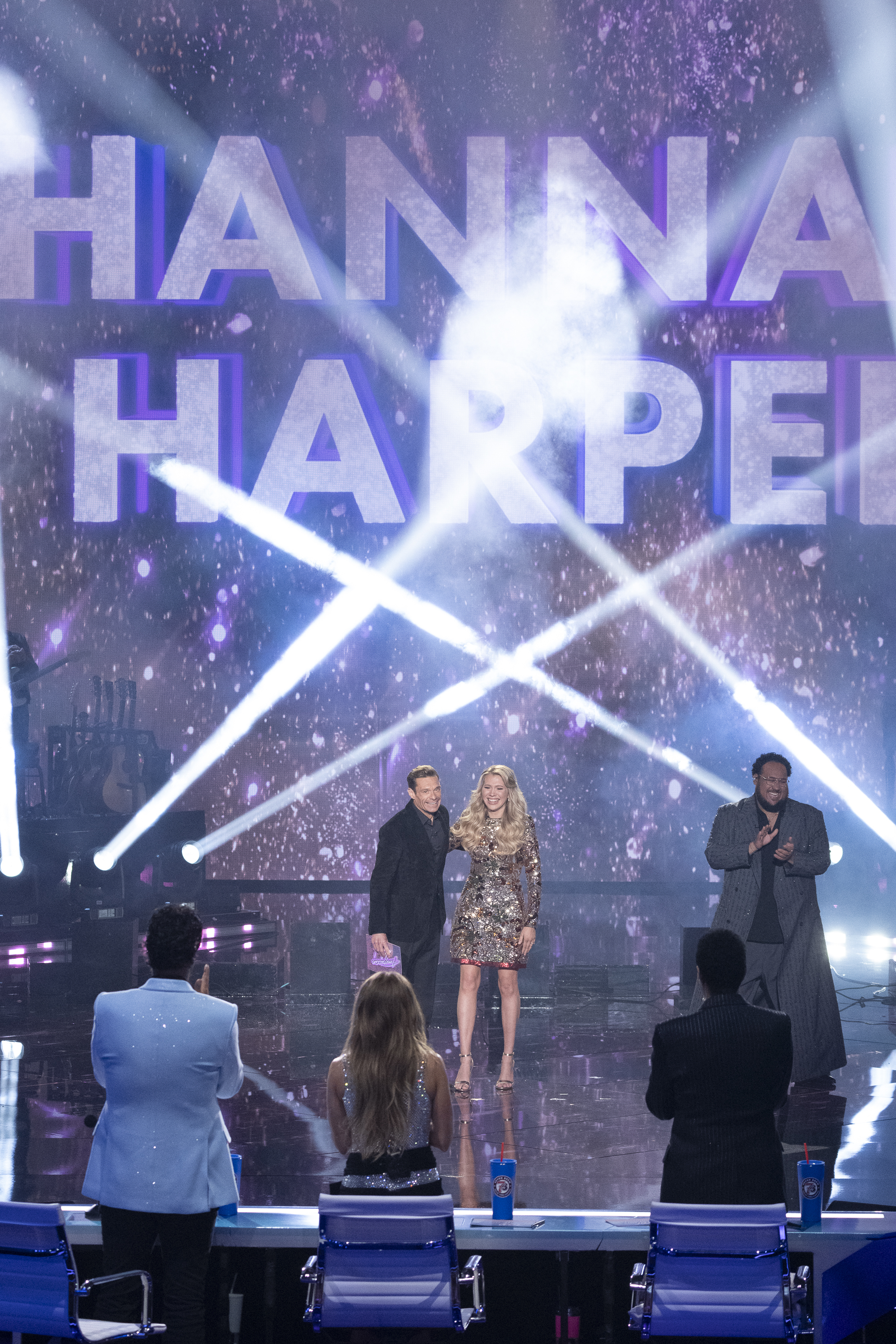 Ryan Seacrest stands beside winner Hannah Harper as Jordan McCullough applauds on the side during the "American Idol" Season 24 finale | Source: Getty Images