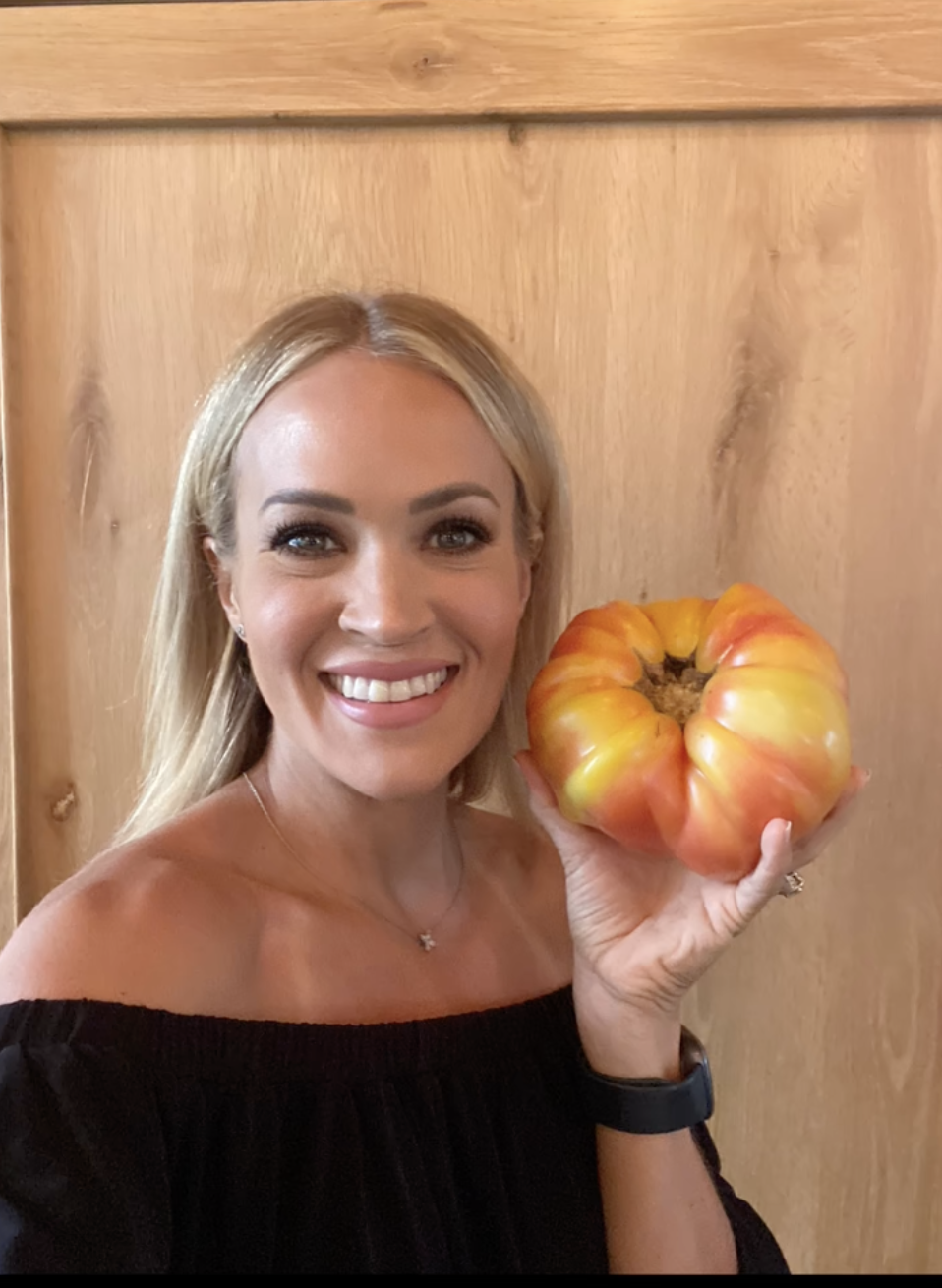 Carrie Underwood pictured holding a large tomato on July 21, 2022 | Source: TikTok/carrieunderwood