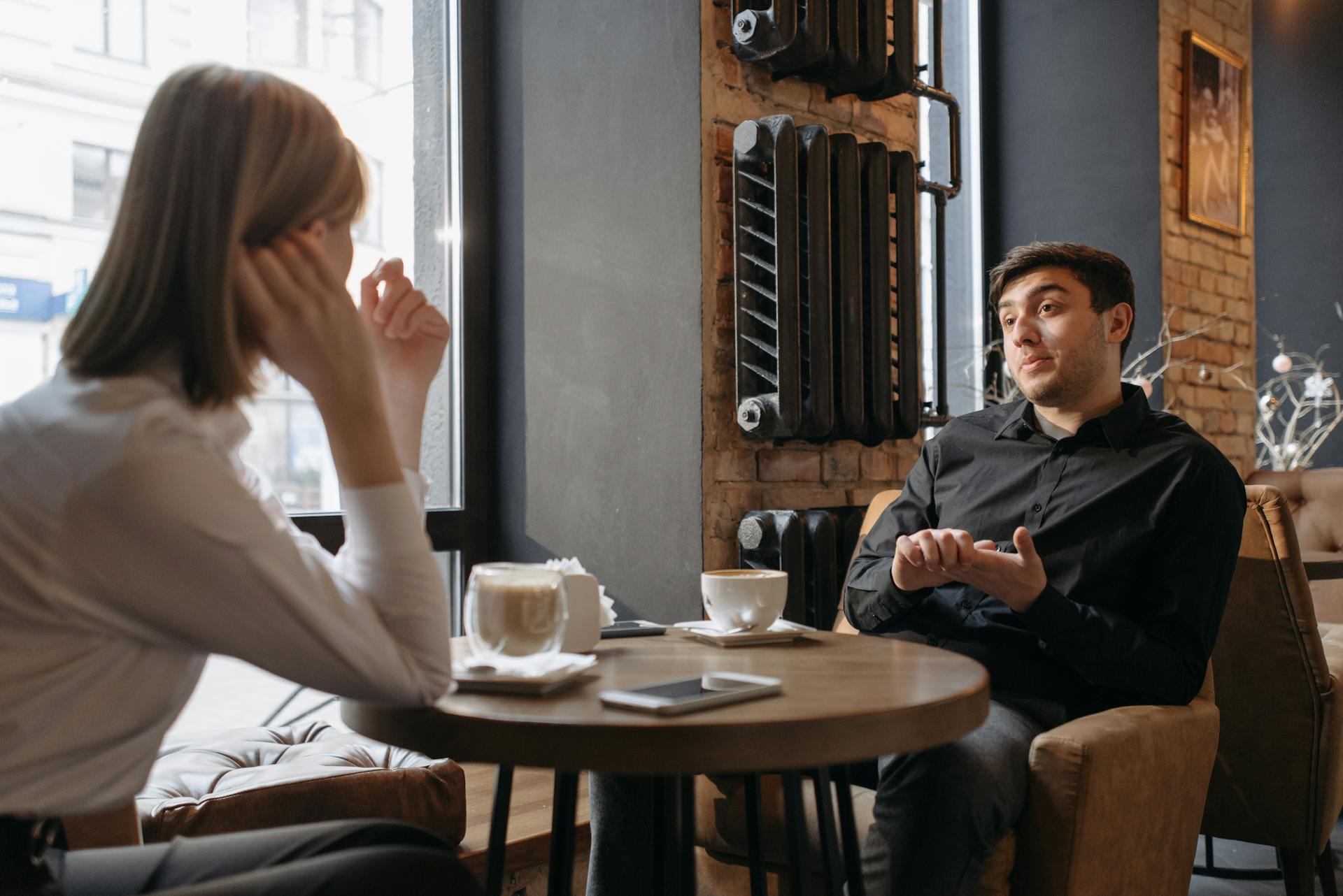 Couple seated in a coffee shop | Source: Pexels