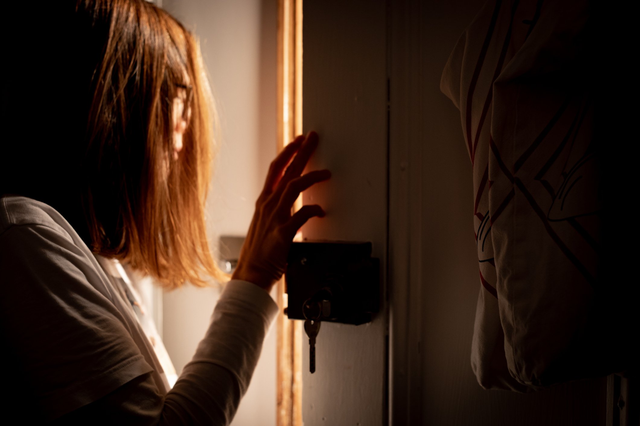 Mujer joven abre la puerta de su hogar. | Foto: Getty Images