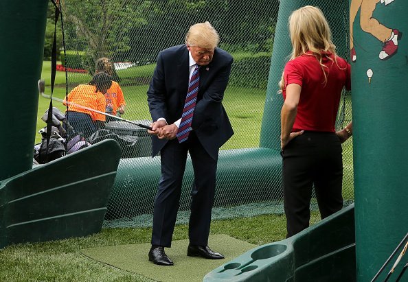 Donald Trump swings a golf club during the White House Sports and Fitness Day on the South Lawn on May 30, 2018 in Washington, DC | Photo: Getty Images
