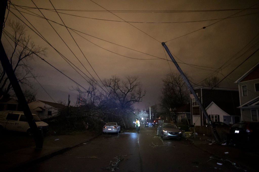 In the wake of a tornado, a Nashville resident shine a light on the debris and damage as she made her way down Underwood St. on March 3, 2020, in Nashville, Tennessee | Source: Brett Carlsen/Getty Images