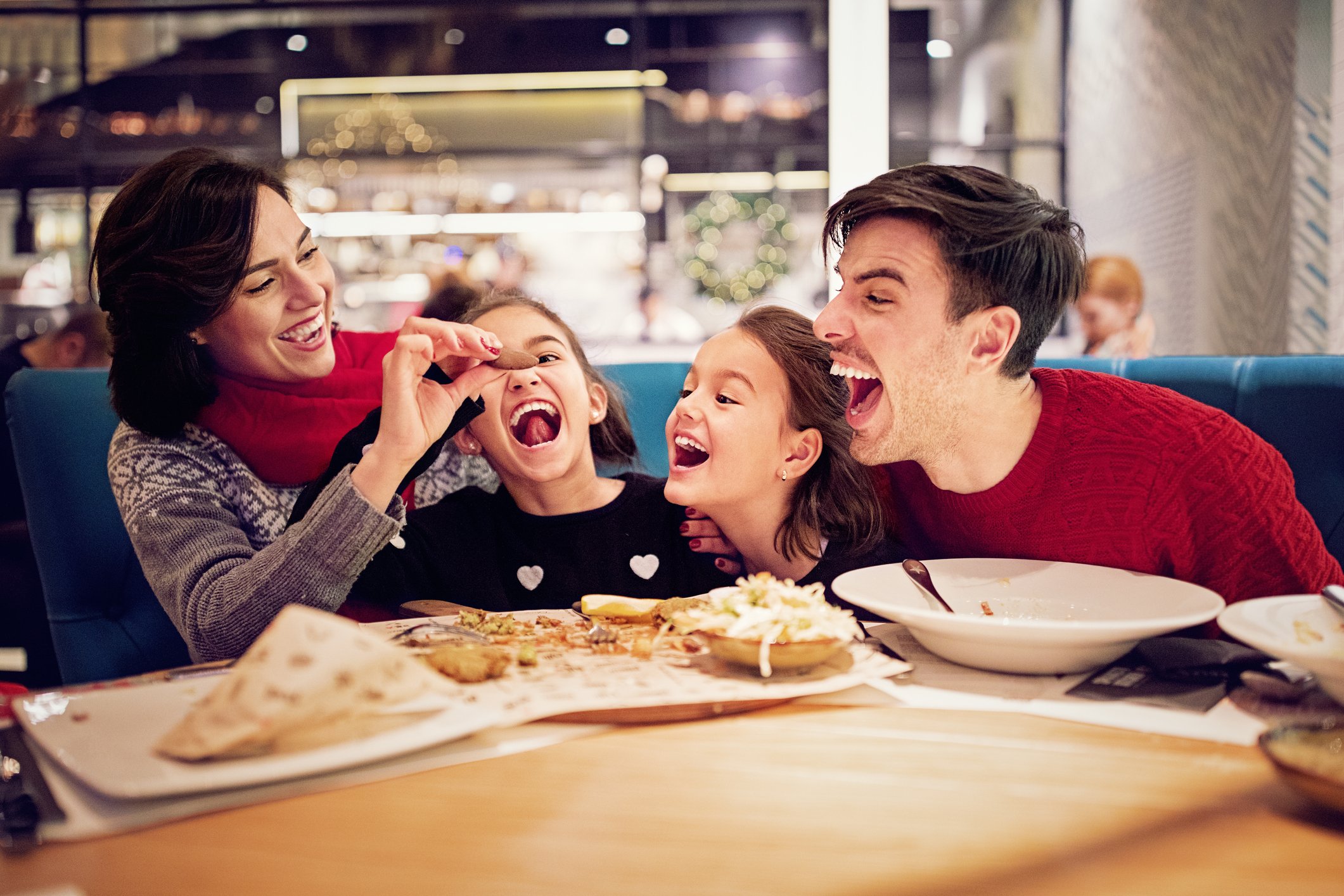Porträt des glücklichen Familienessens im Restaurant zu Weihnachten I Quelle: Getty Images