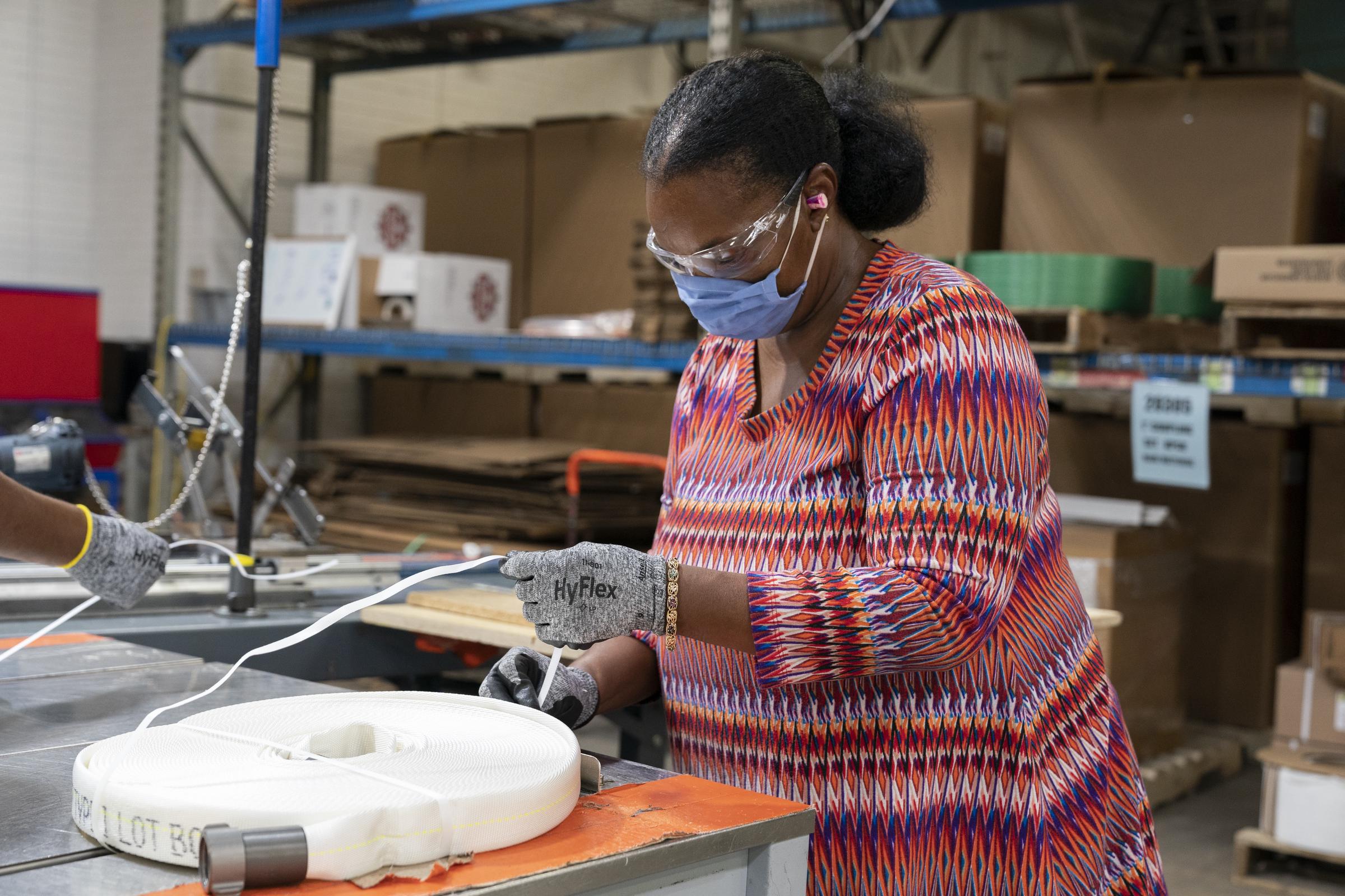 A worker prepares a fire hose for shipping at the NewView Oklahoma facility in Oklahoma City, on September 16, 2021 | Source: Getty Images