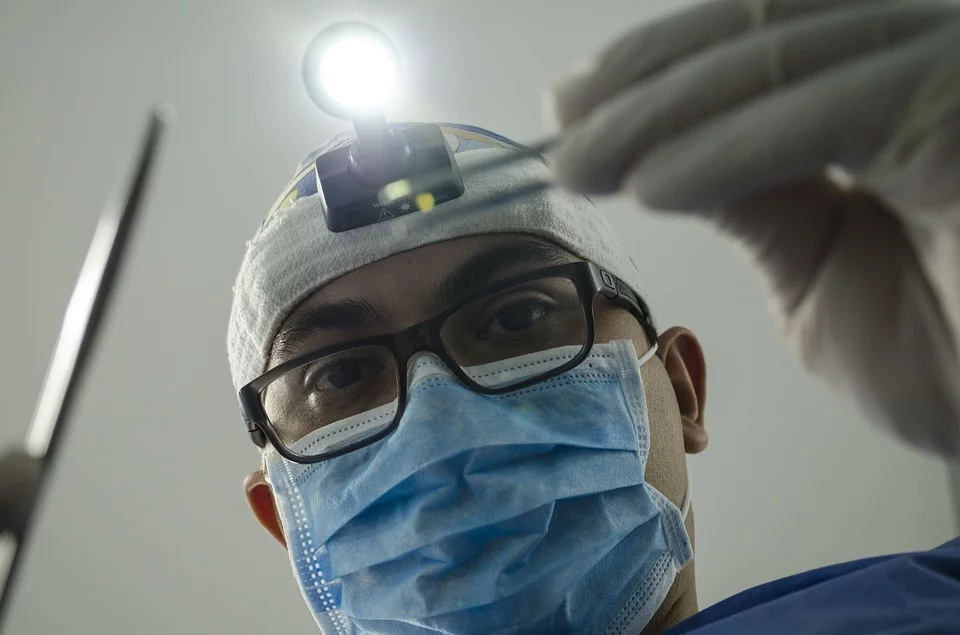 Médico con mascarilla y gorro realizando un procedimiento en el hospital. | Foto: Pixabay