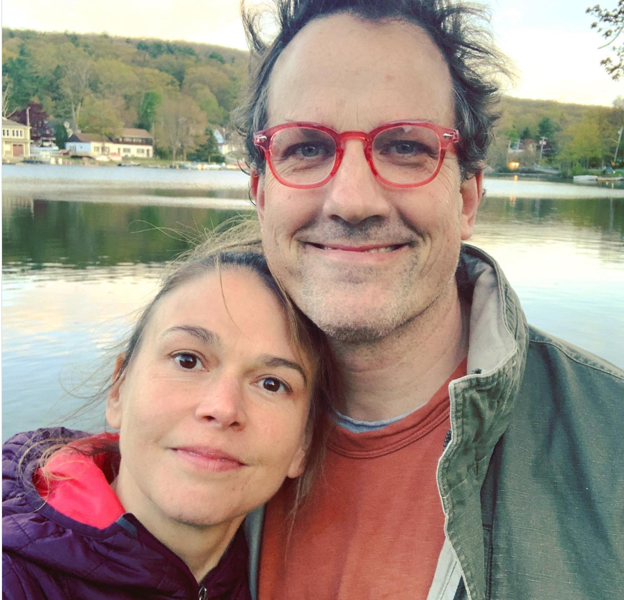 Sutton Foster poses beside Ted Griffin during a quiet lakeside moment surrounded by calm water and greenery. | Source: Instagram/suttonlenore