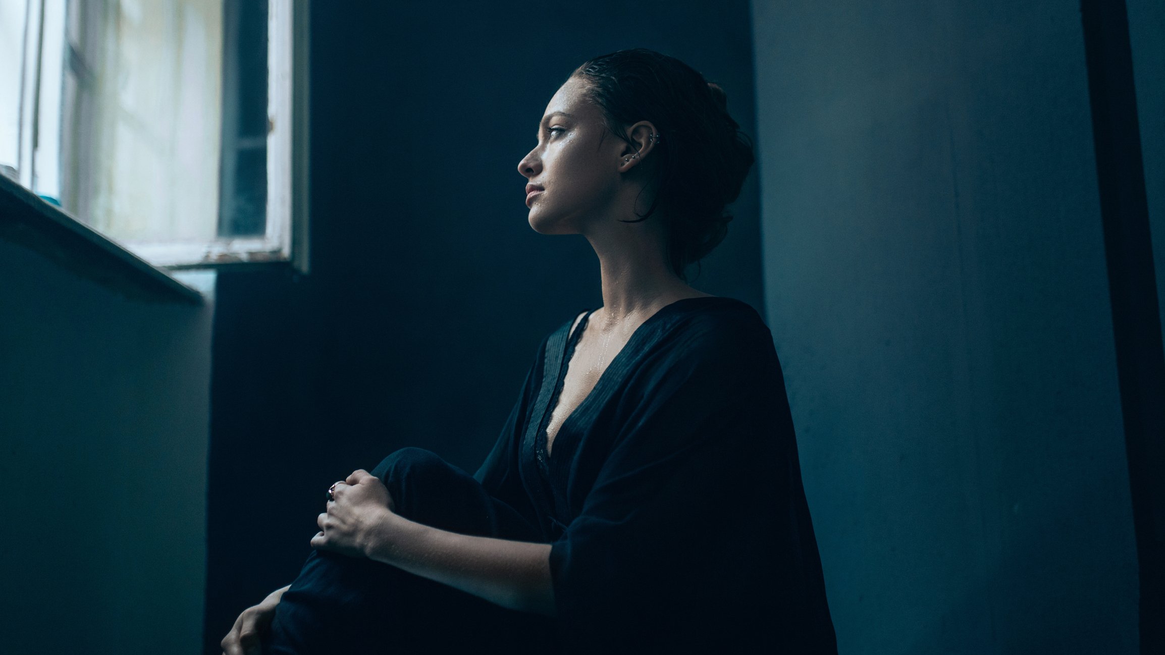 Une femme regardant tristement par la fénêtre | source : Getty Images