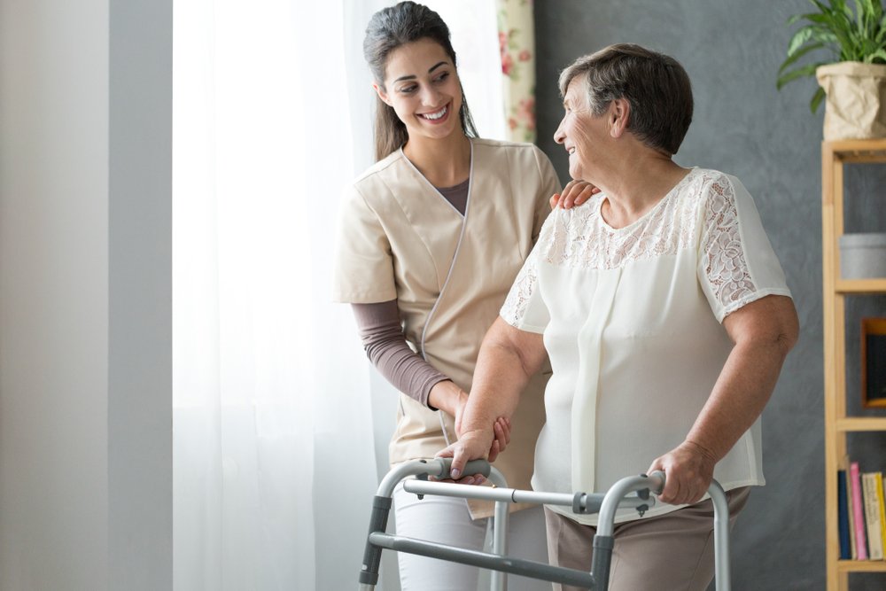 A photo of beautiful caregiver helping an old lady at a nursing home. | Photo: Shutterstock.