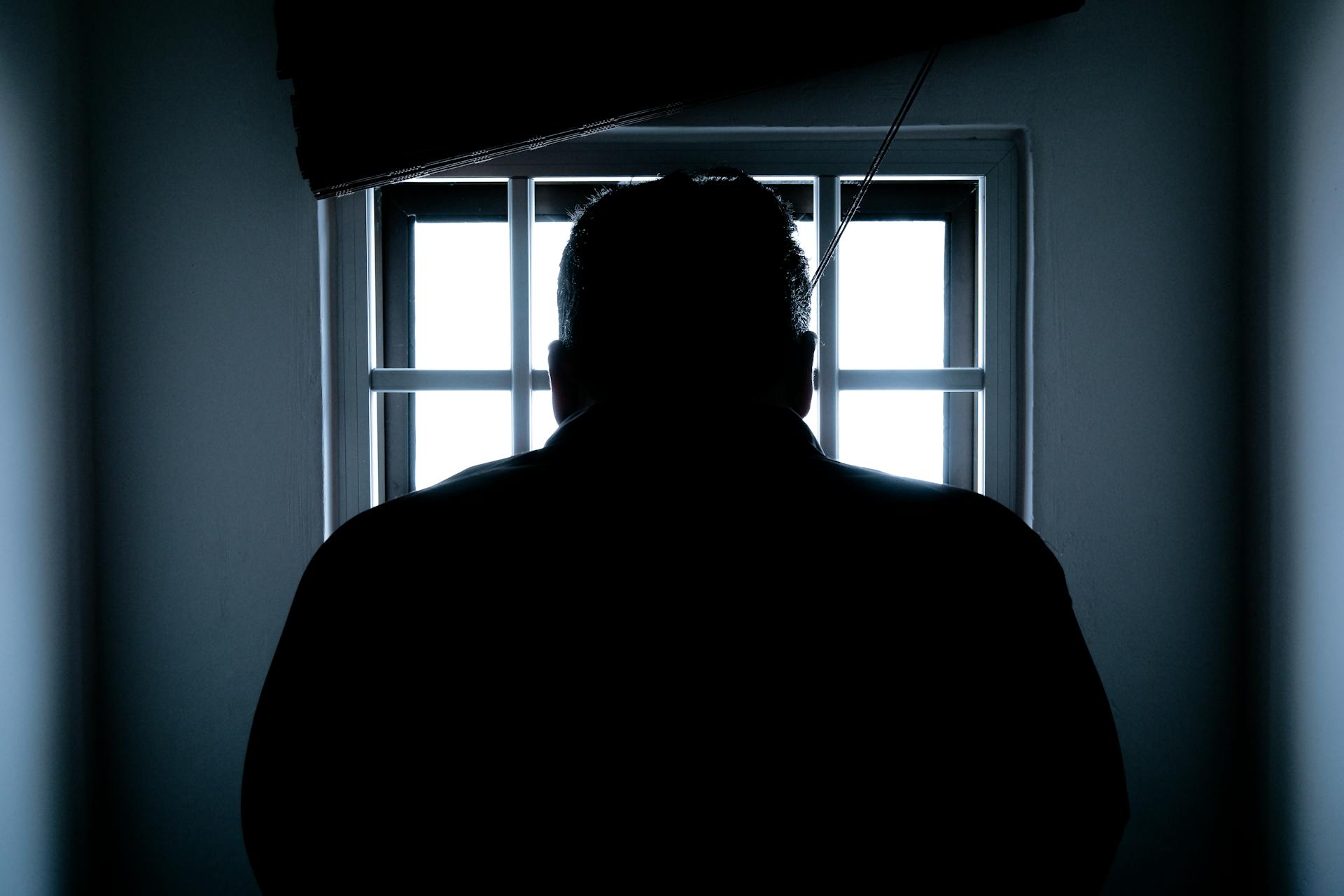 A silhouette of a man sitting in jail | Source: Pexels