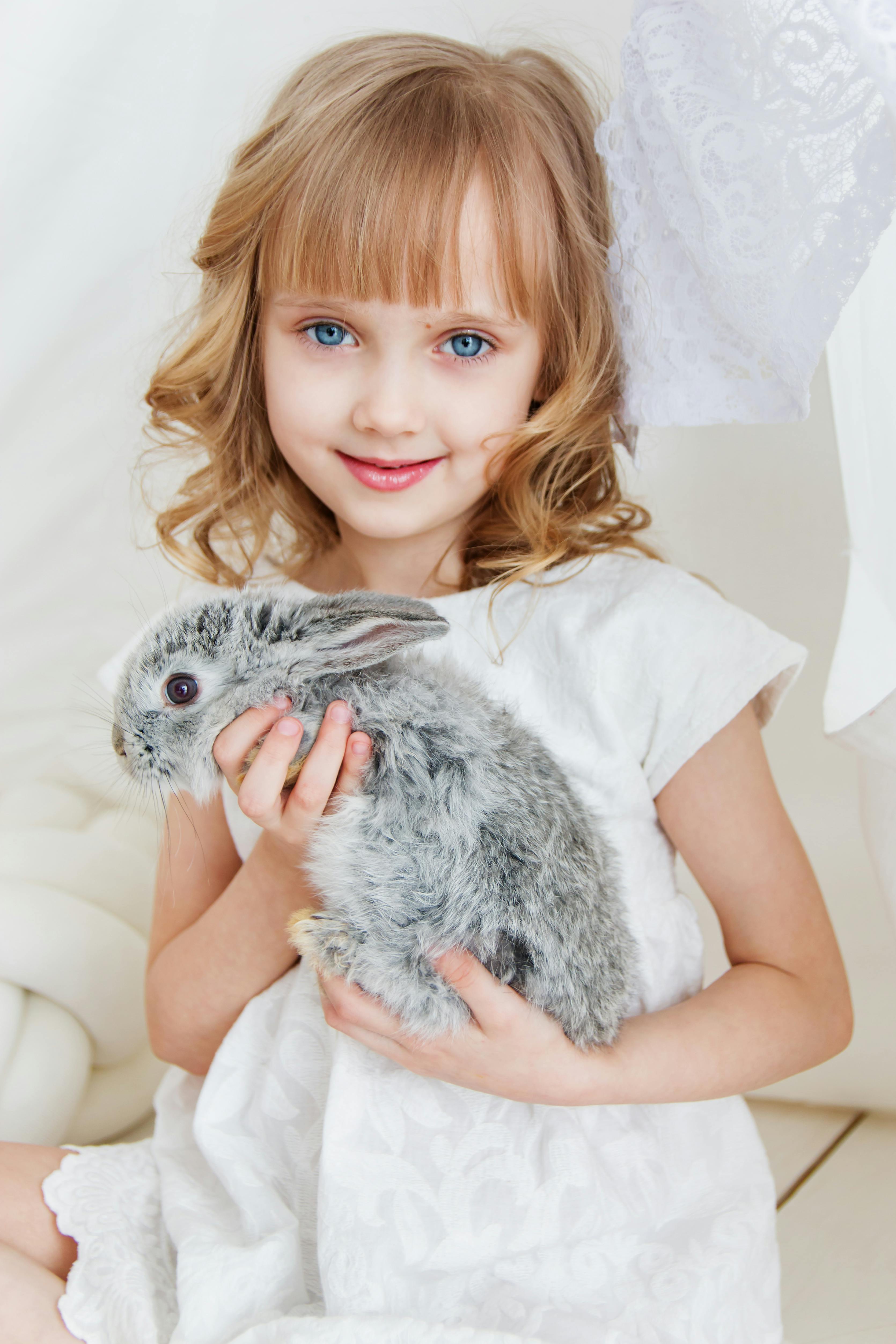 A smiling girl with a rabbit | Source: Pexels