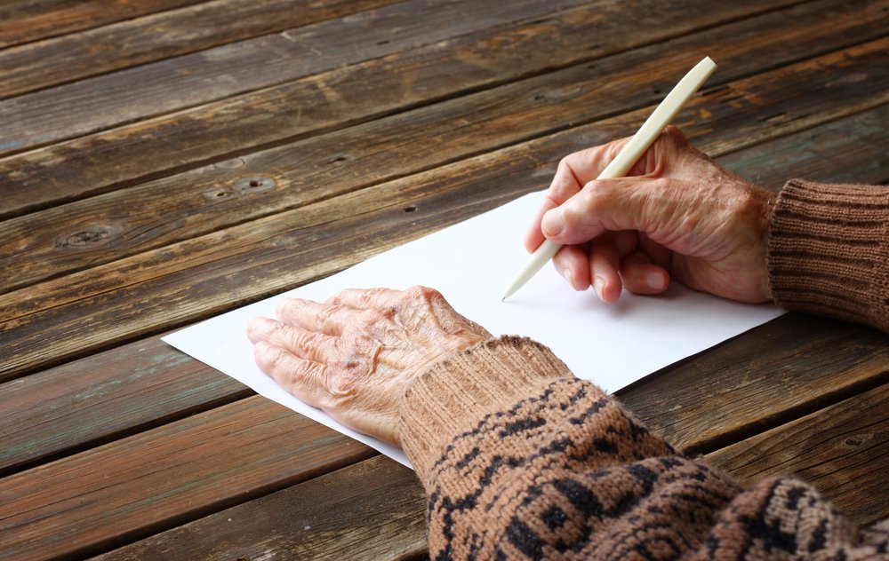 Anciana escribiendo una nota. | Foto: Shutterstock.