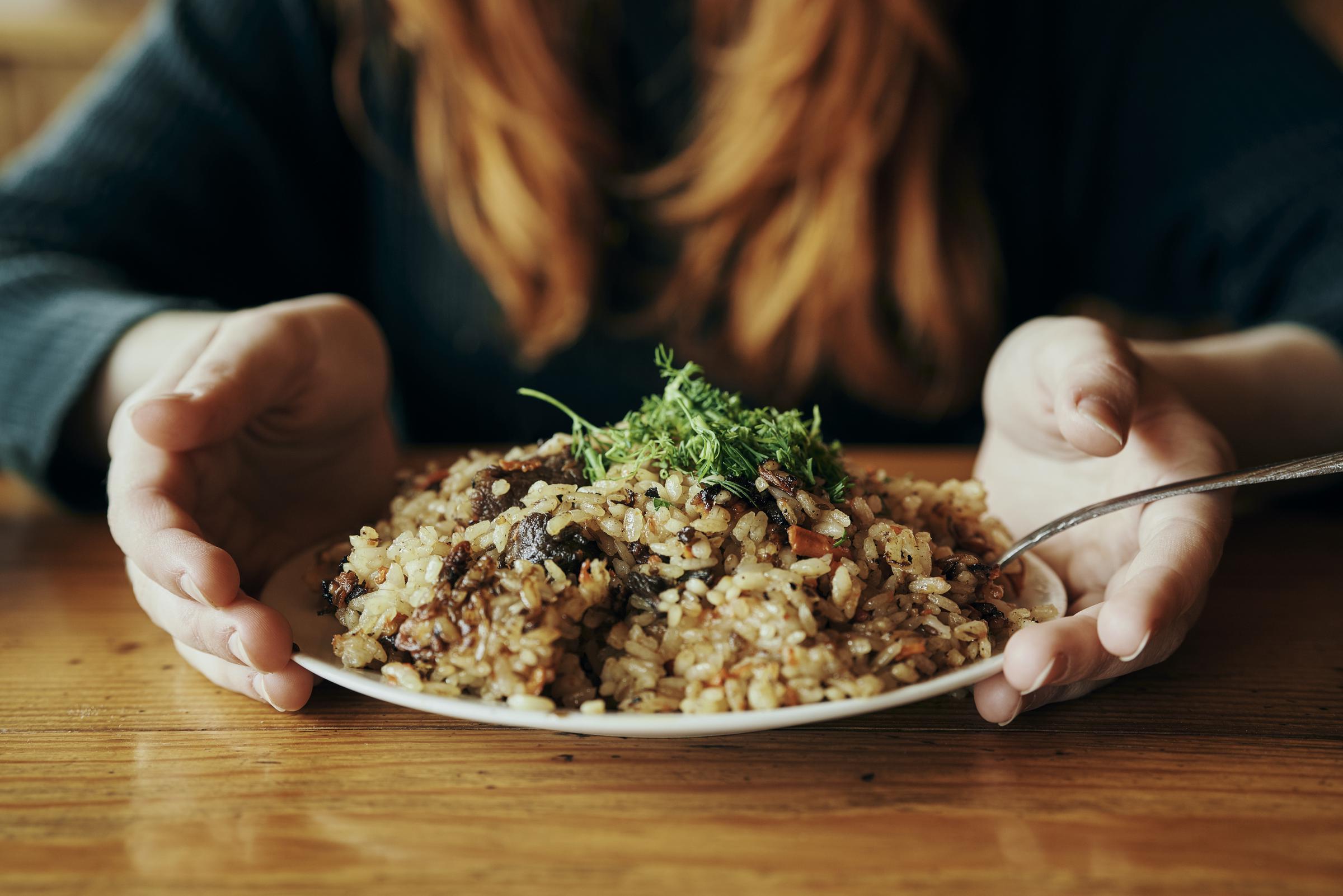 A woman holding a plate of rice | Source: Getty Images