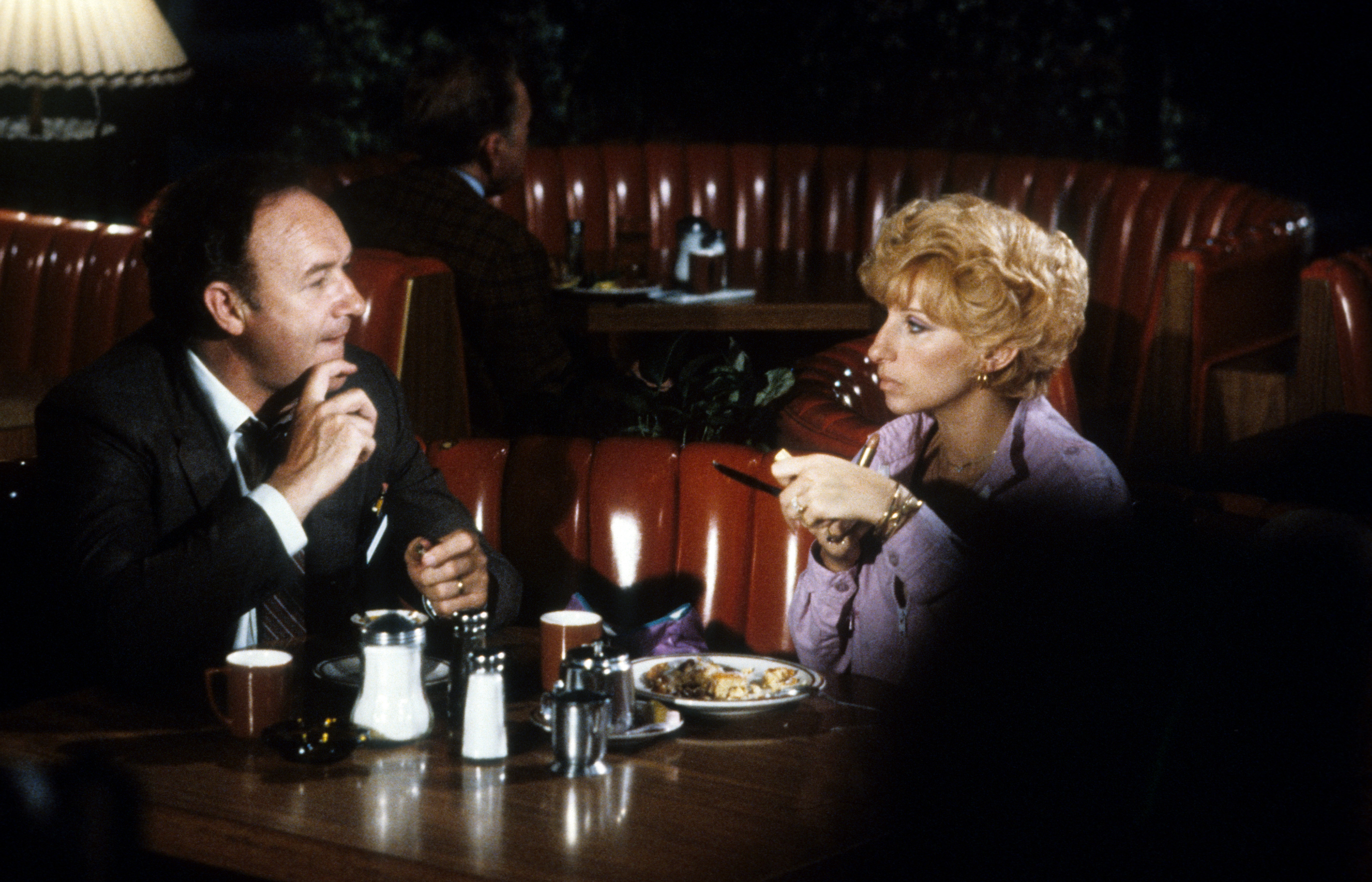 Gene Hackman and Barbra Streisand sit in a booth, dining together in a scene from the 1981 film "All Night Long." | Source: Getty Images