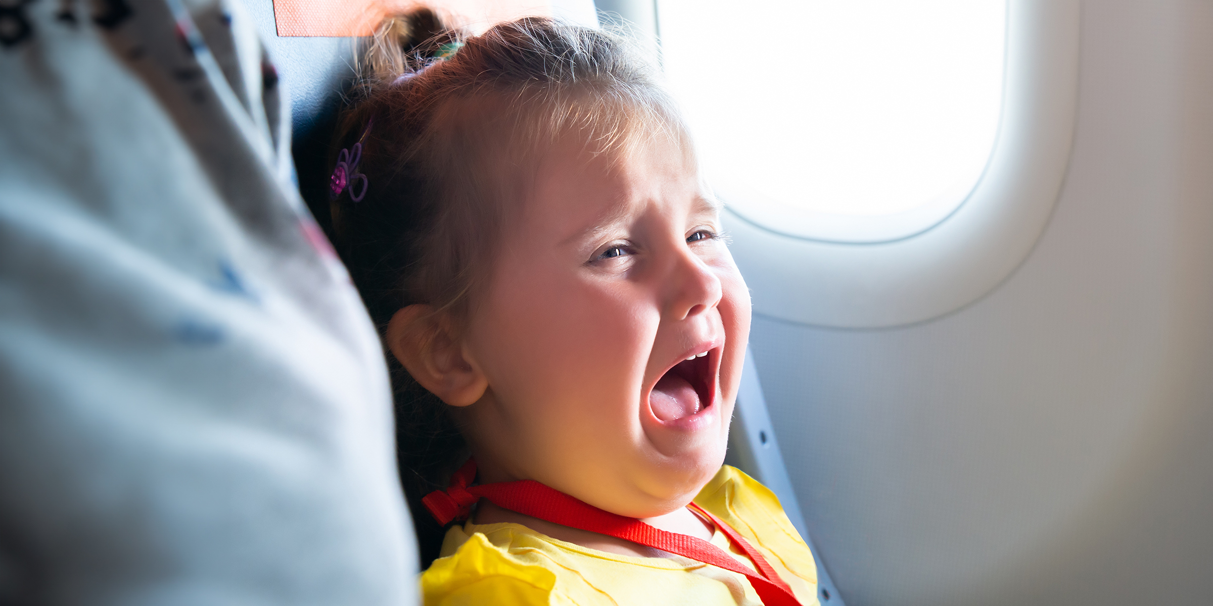 A little girl crying in an airplane | Source: Shutterstock