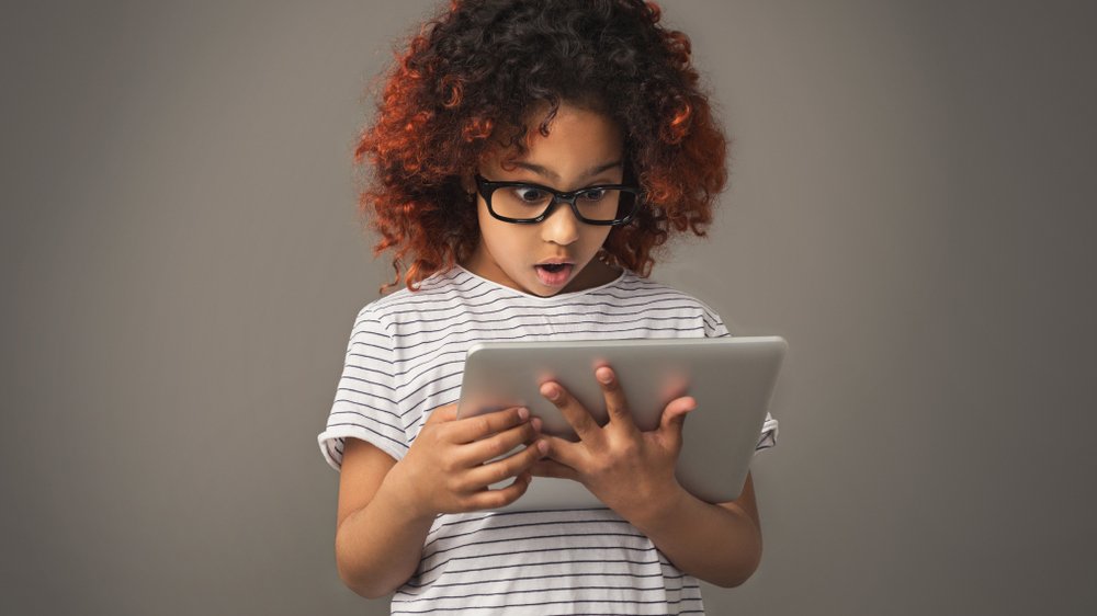 Shocked young girl views something on a tablet | Photo: Shutterstock Shocked young girl views something on a tablet | Photo: Shutterstock