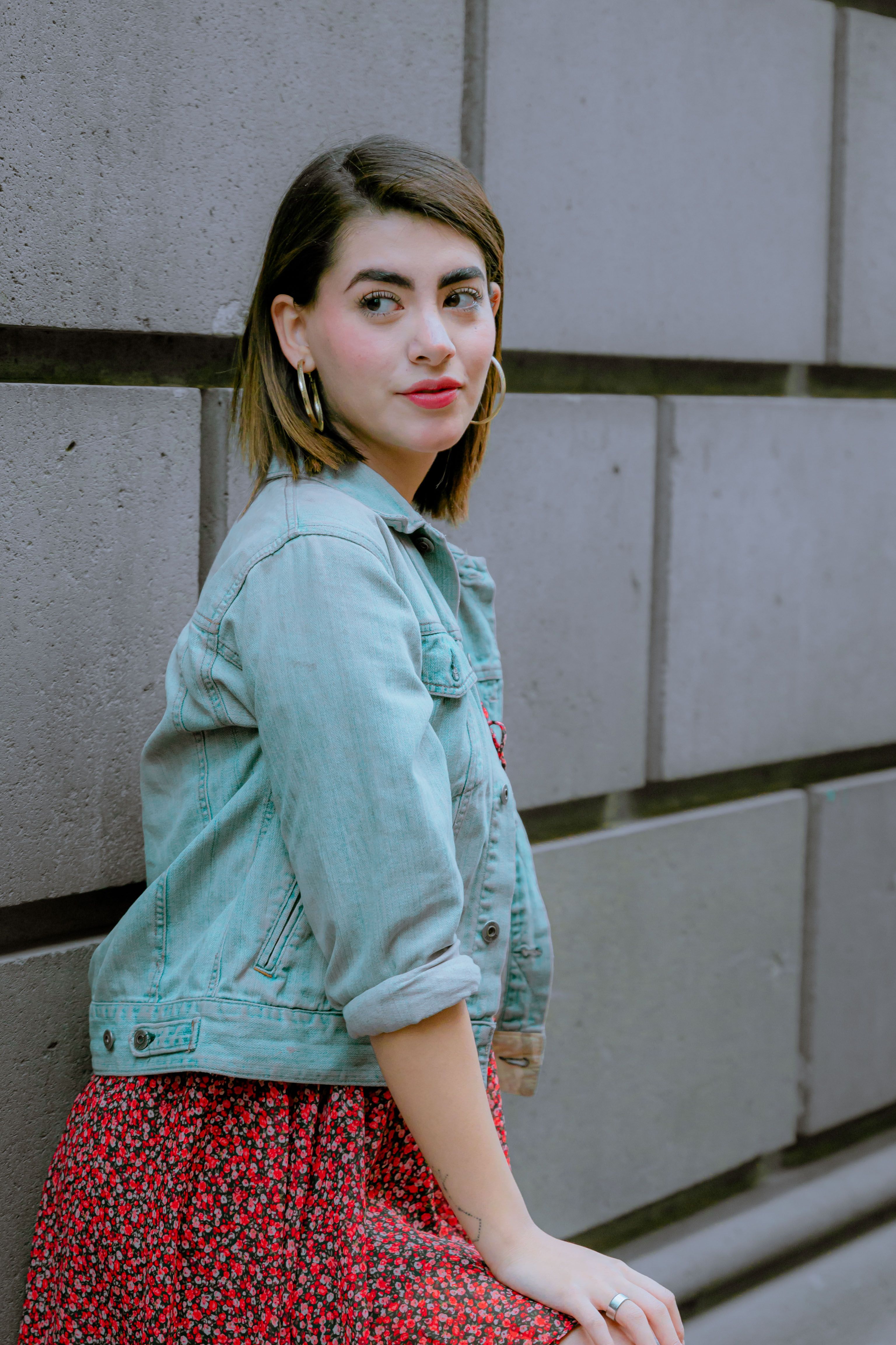 Woman wearing a denim jacket over a summer dress | Source: Pexels