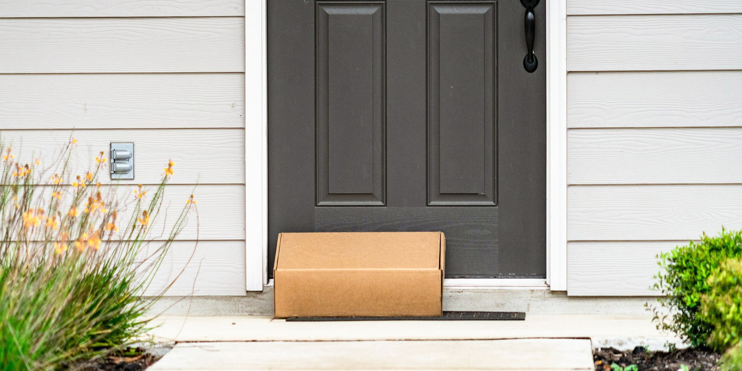 A cardboard box on a front door porch | Source: Shutterstock
