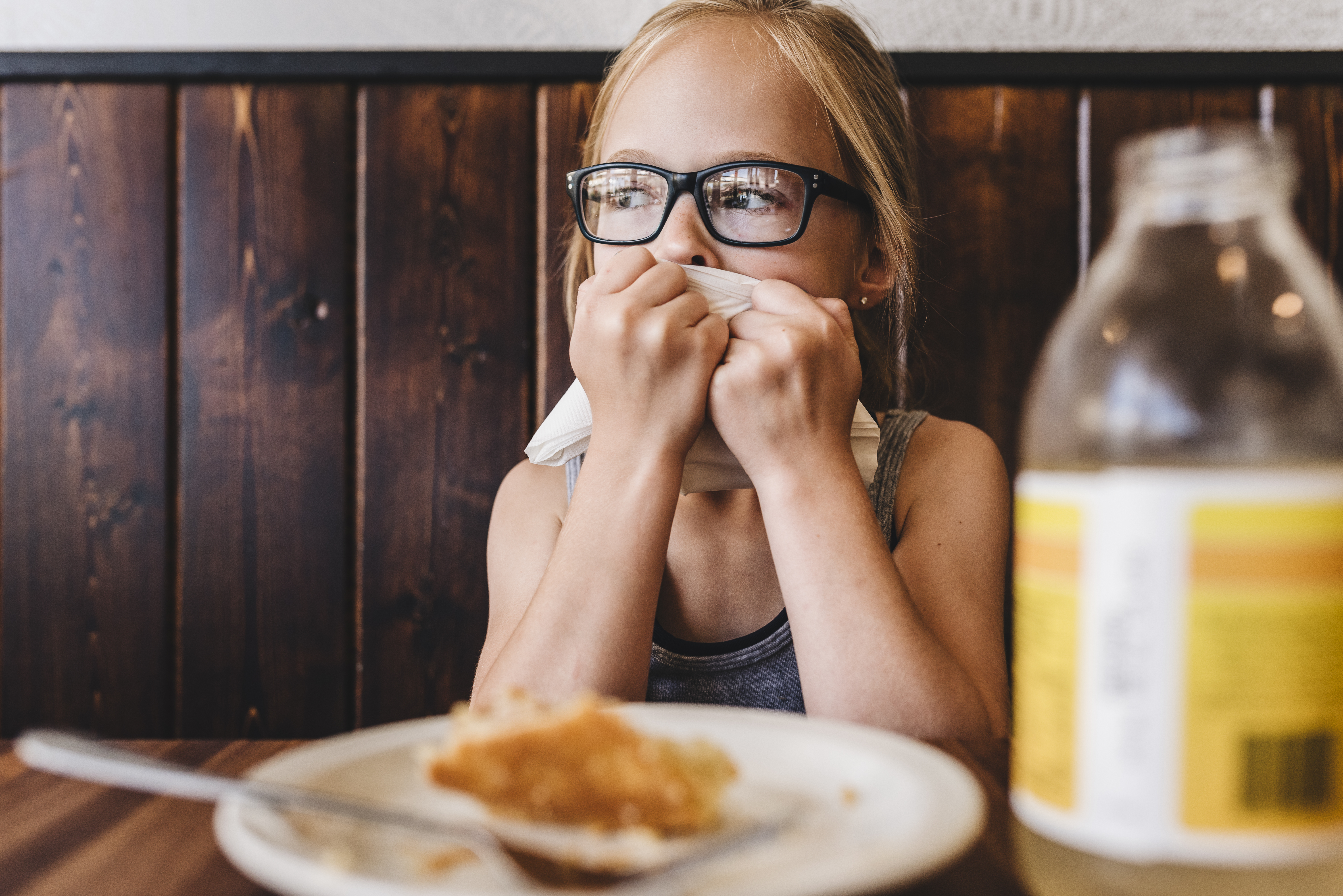 Little girl eats and drinks at table in cafe restaurant | Source: Getty Images