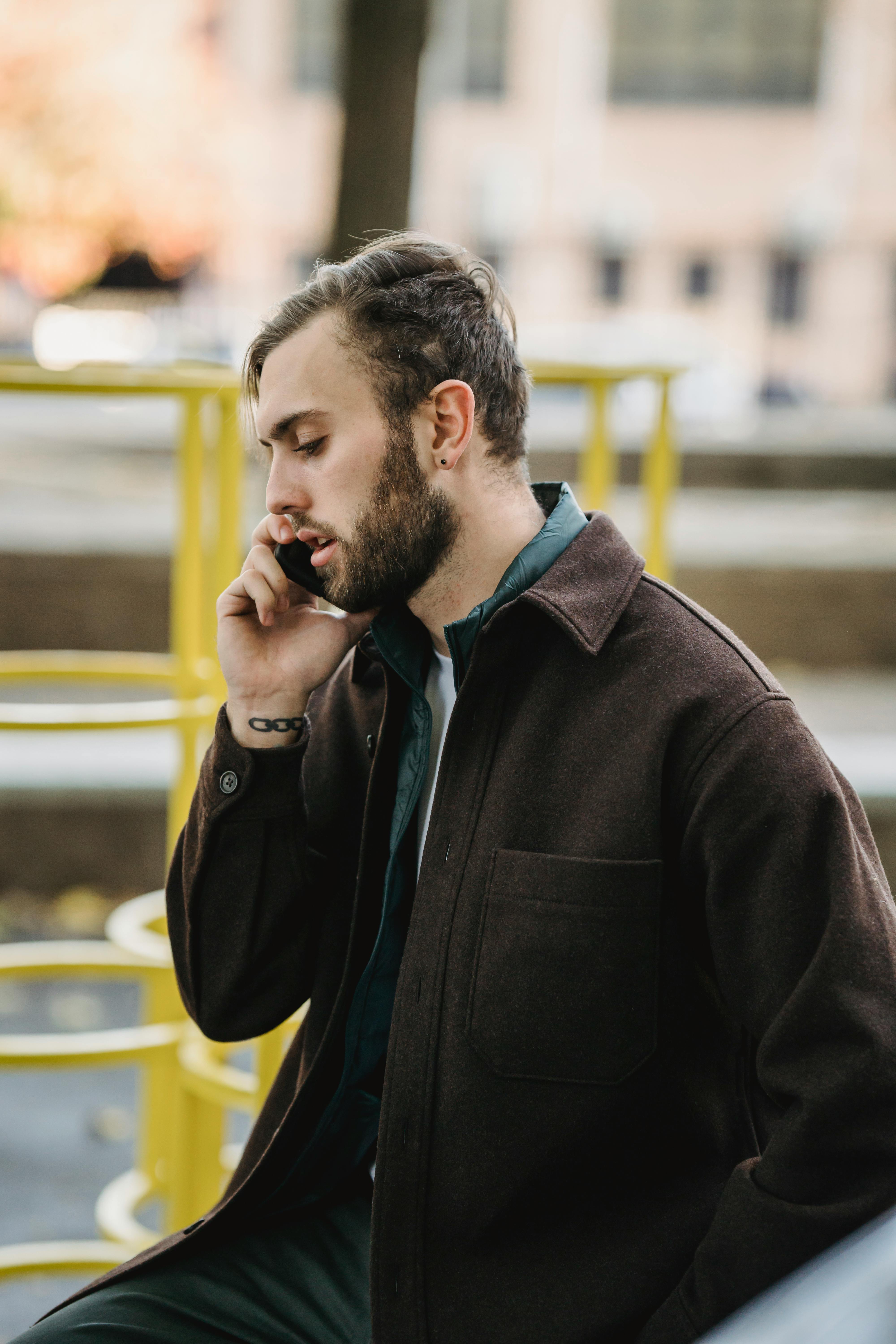 An unhappy-looking man talking on the phone | Source: Pexels