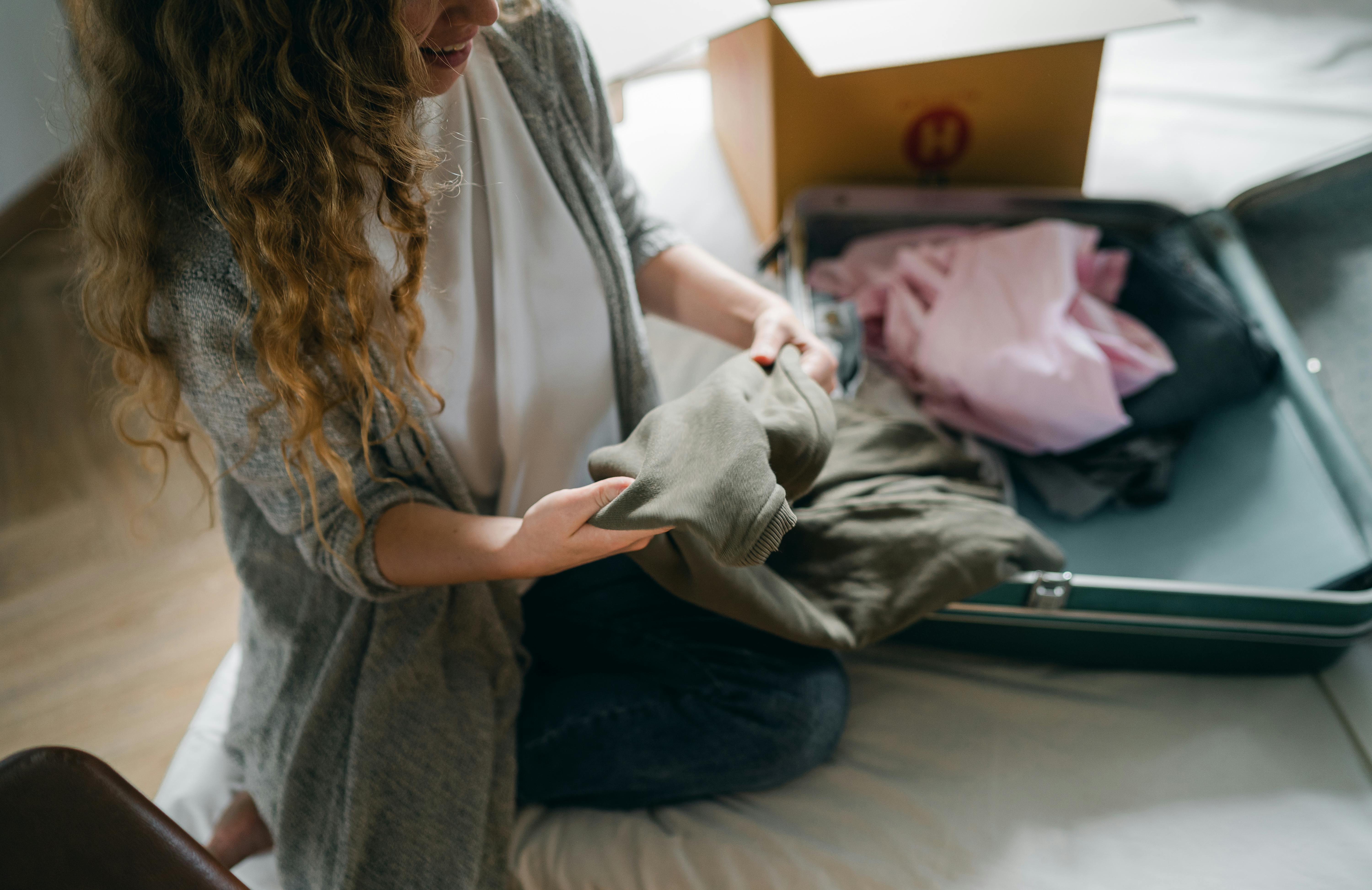 Une femme range ses vêtements dans un sac | Source : Pexels