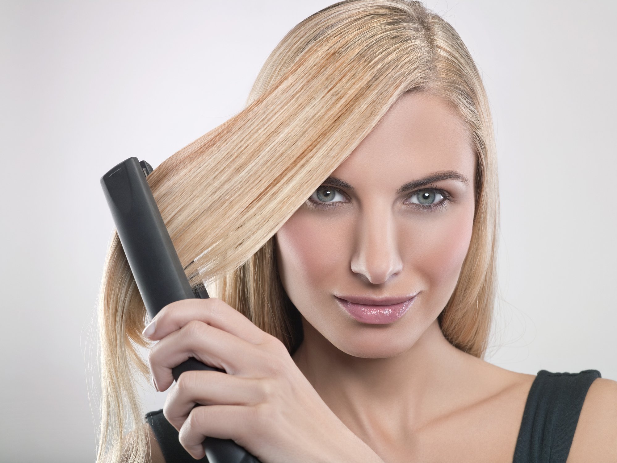 Une femme qui lisse ses cheveux. | Photo : Getty Images