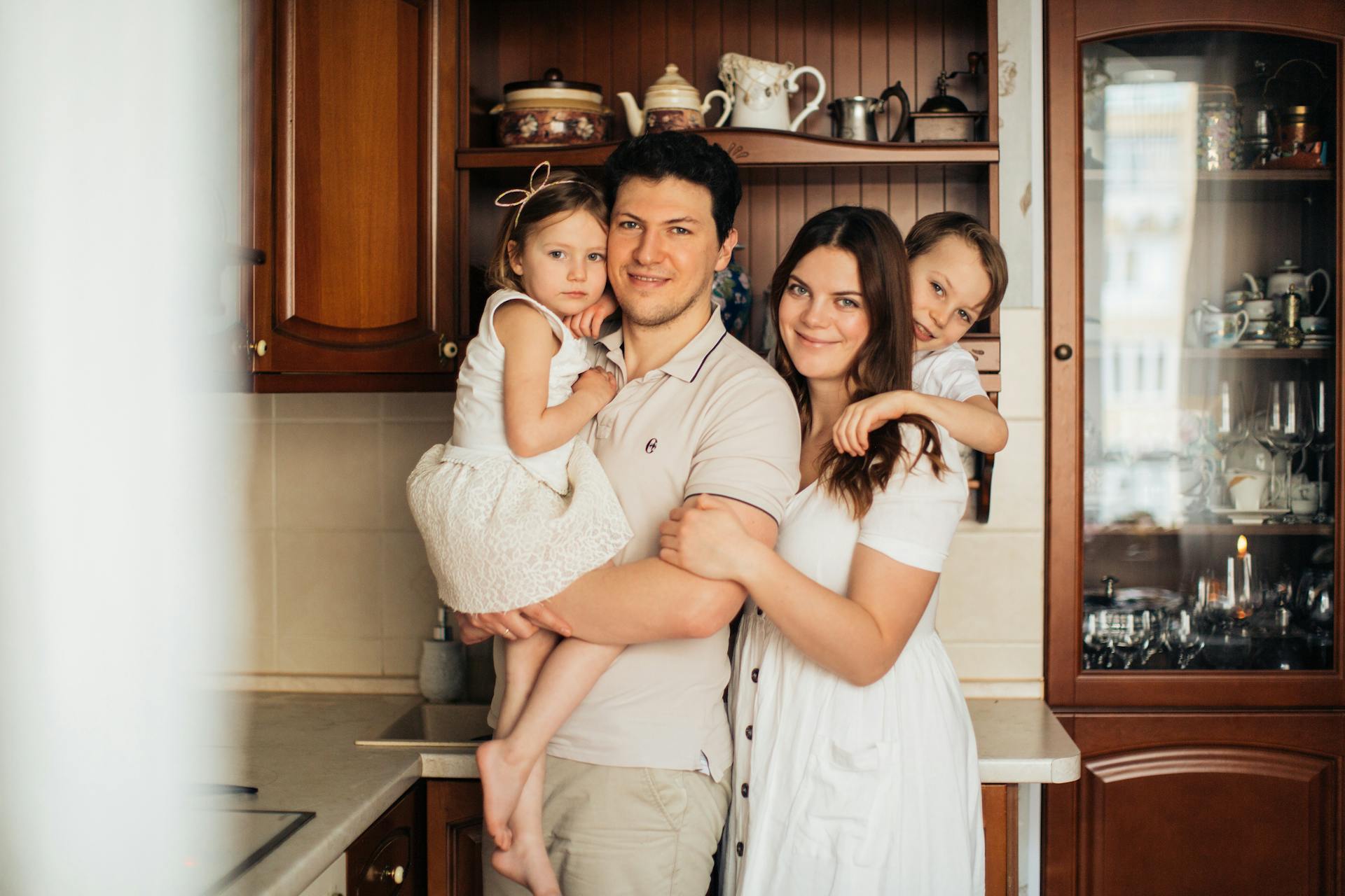 A couple standing in the kitchen with their kids | Source: Pexels