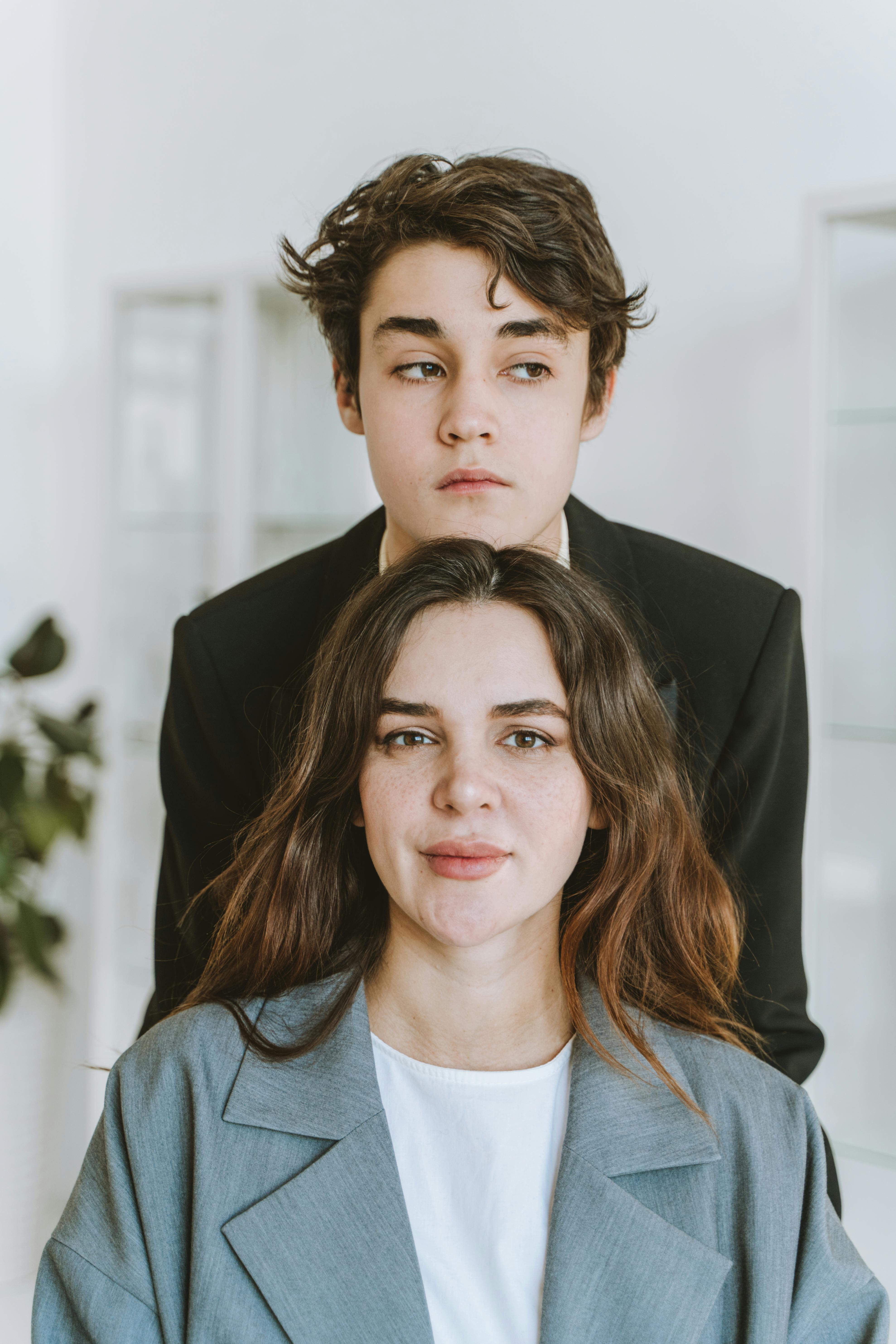 A mother sitting while her young boy stands behind her | Source: Pexels